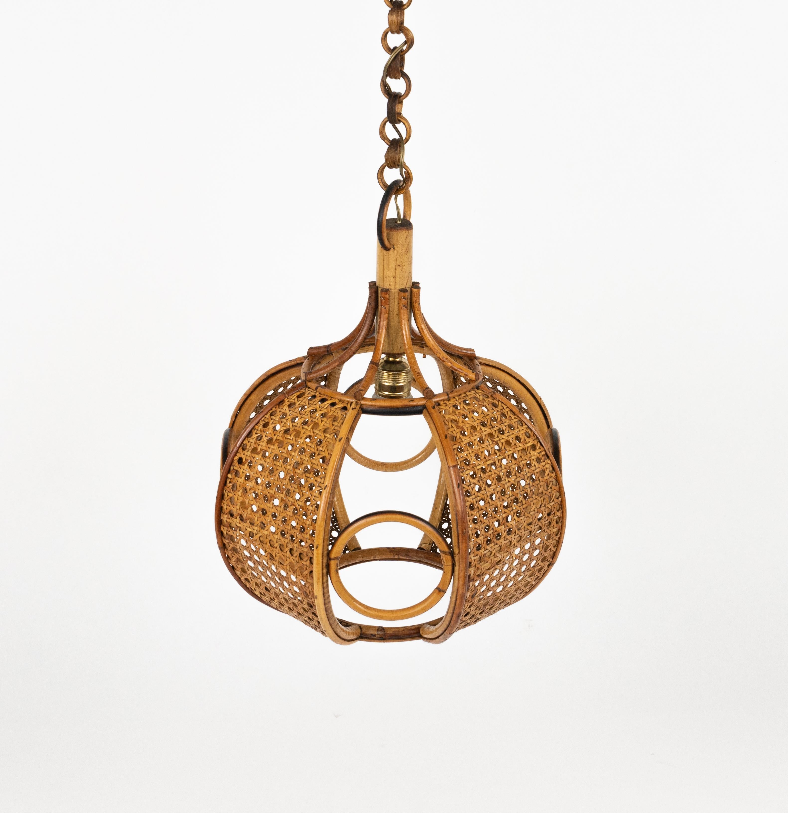 Midcentury beautiful hand-crafted chandelier in rattan and wicker with chain with round rattan links which can be shortened to adjust it to the desired height.

Made in Italy in the 1960s.

New electrical system, they are wired for the United States