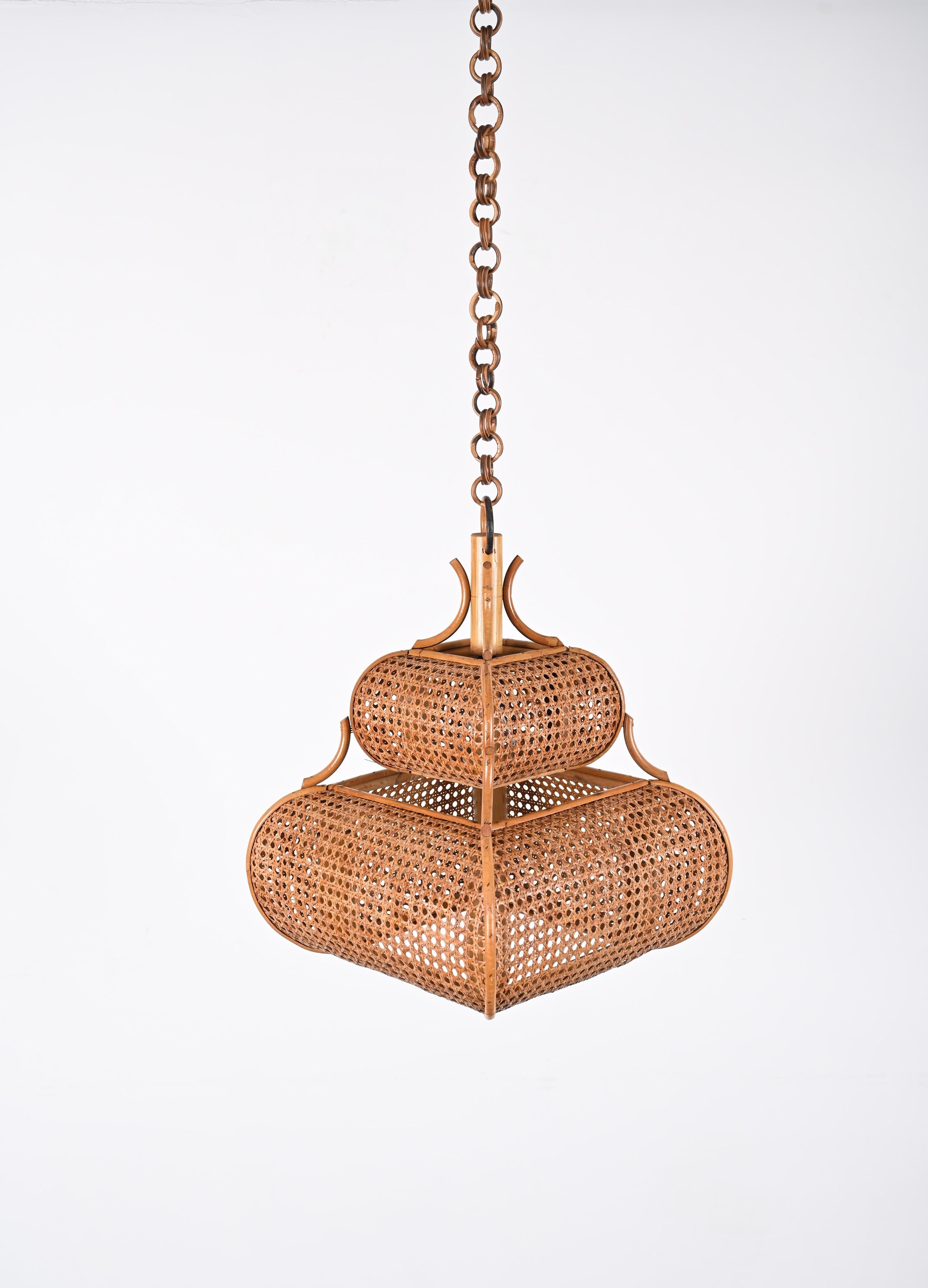 Astonishing rattan and wicker pendant chandelier in French Riviera style. This incredible piece was produced in Italy during the 1960s.

The pendant features a gorgeous double shade in hand-woven Vienna straw wicker and a chapel shaped structure