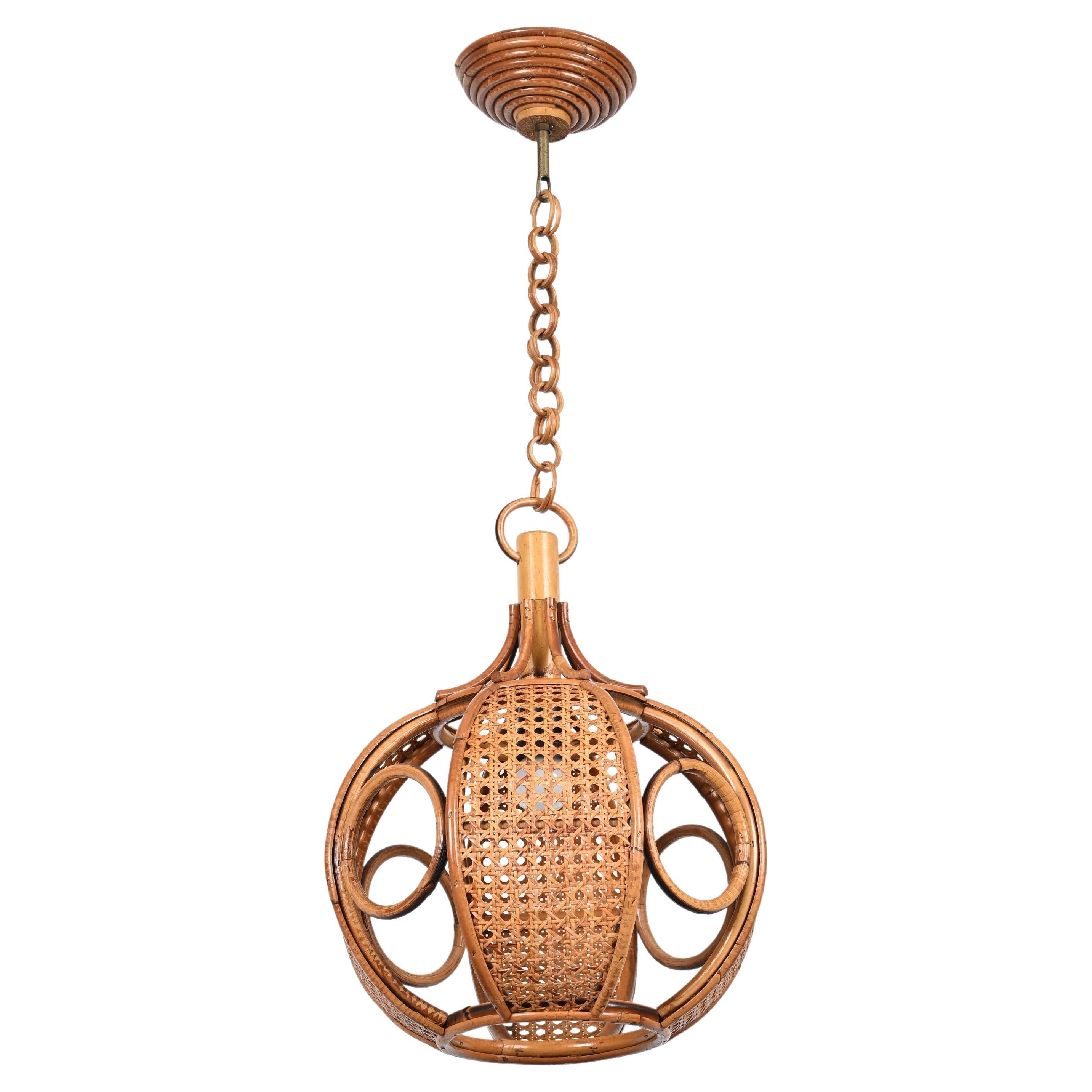 Marvellous rattan and wicker pendant chandelier in French Riviera style. This incredible piece was realized in Italy during the 1960s.

This unique pendant features a gorgeous shade in hand-woven Vienna straw wicker, curved rattan and bamboo. The