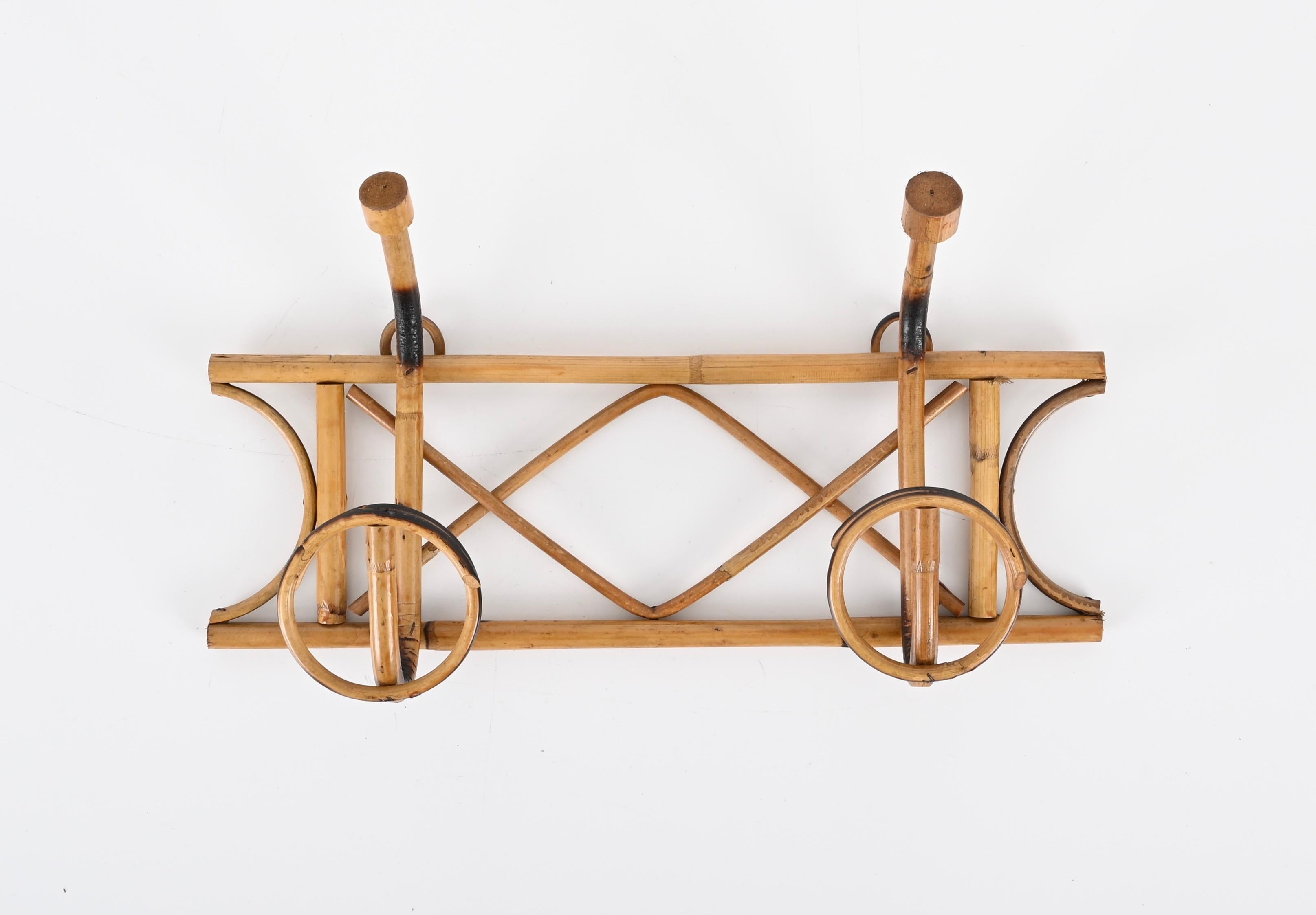 Beautiful Riviera style wall coat hanger, entirely made in curved rattan and bamboo. This lovely French Riviera coat hanger was made in Italy in during the 1960s.

This stunning item features a bamboo cane frame and two curved rattan top hooks and