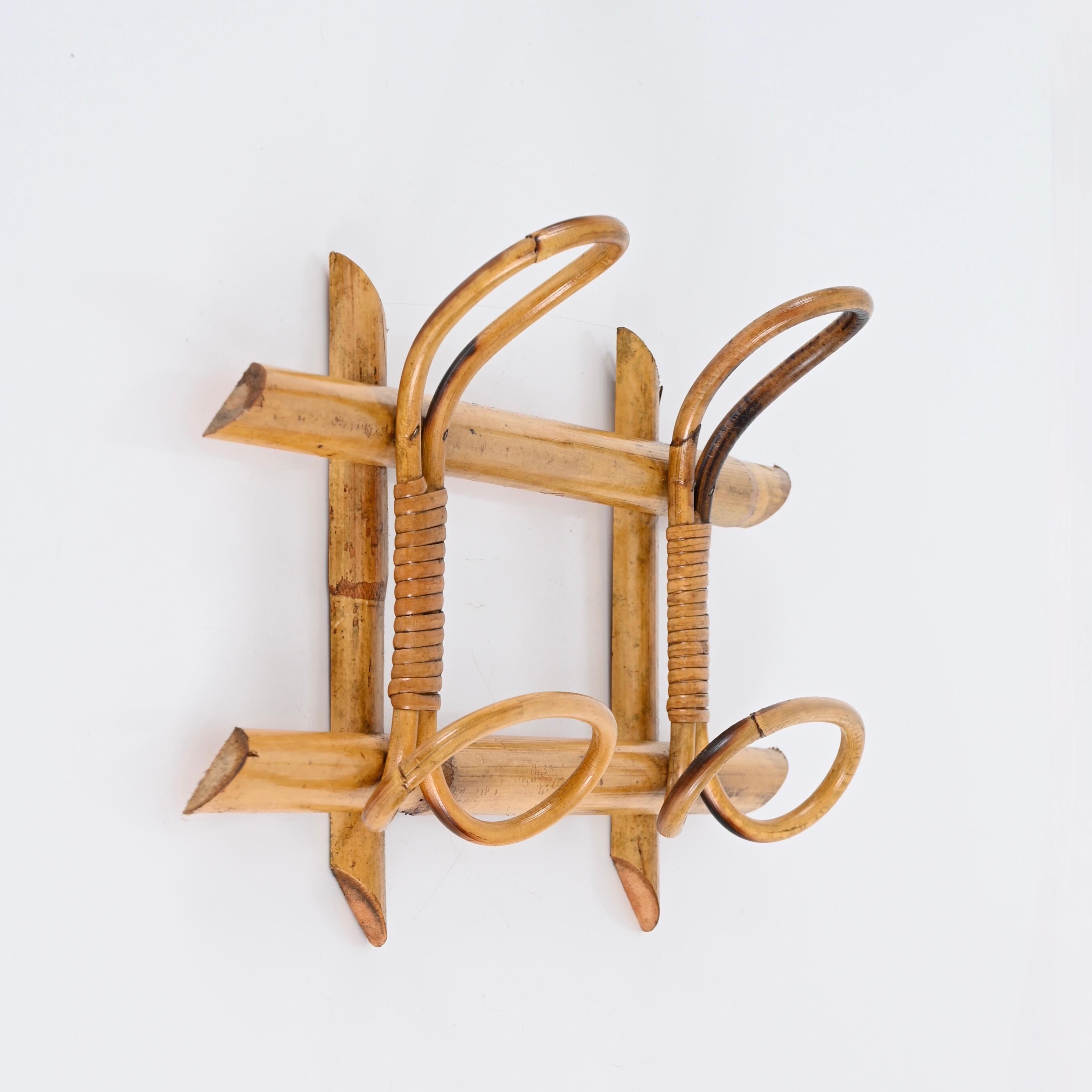 Beautiful Riviera style wall hanger, fully made in curved rattan, bamboo and wicker. This lovely French Riviera coat rack was realized in Italy in the 1960s. 

This stunning item features a structure in bamboo canes and two curved rattan upper hooks
