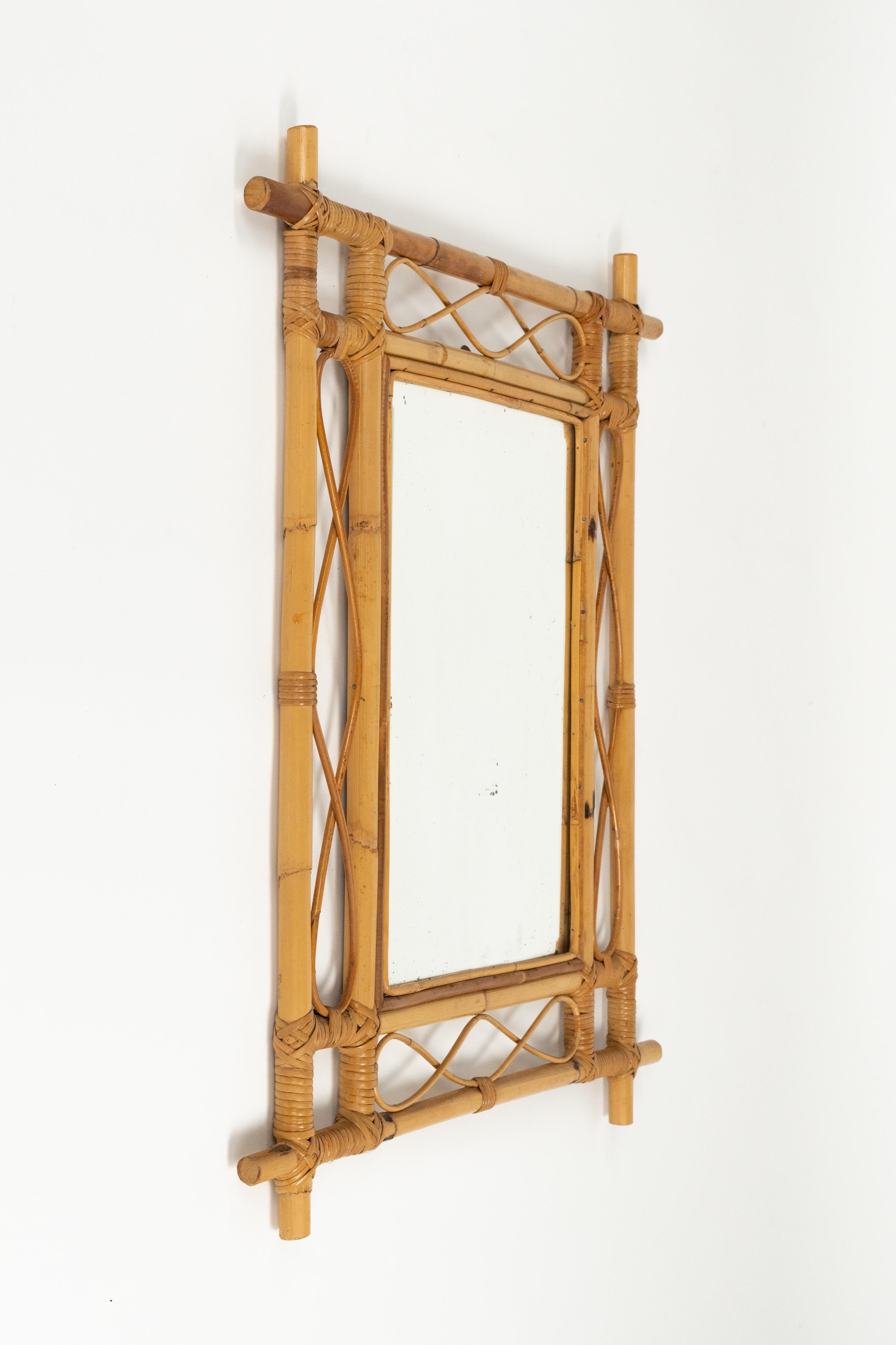Wunderschöner Wandspiegel aus der Mitte des Jahrhunderts aus gebogenem Rattan und Bambus.

Hergestellt in Italien in den 1960er Jahren.

Der Rahmen zeichnet sich durch eine raffinierte Flechtarbeit aus, mit geschwungenen Elementen und gewölbten