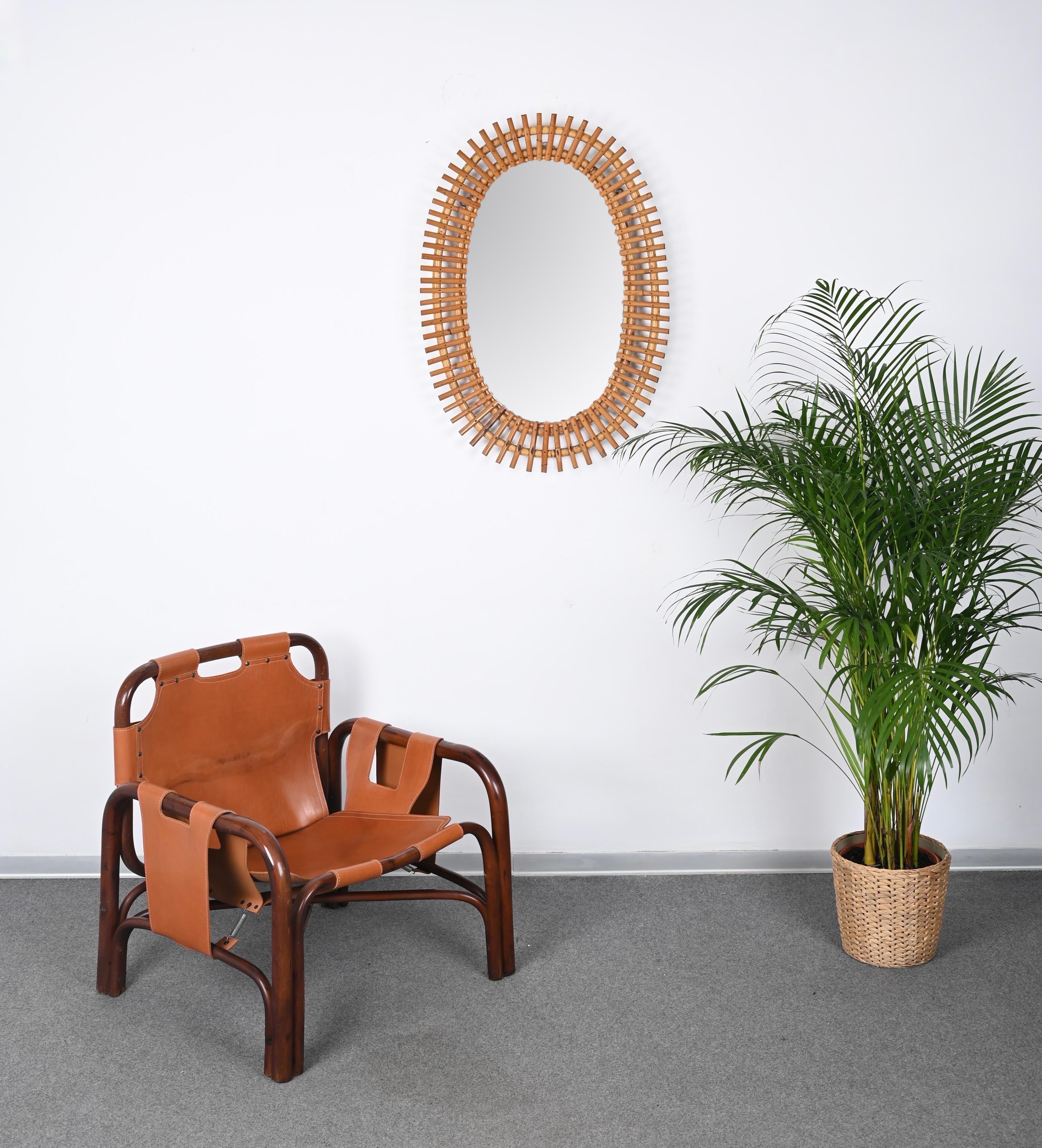 Gorgeous large oval mirror in bamboo and rattan. This fantastic item was realized in Italy in the 1960s. 

This stunning mirror features a triple convex oval frame in curved bamboo crossed by small bamboo inserts.
It has the unmistakable design