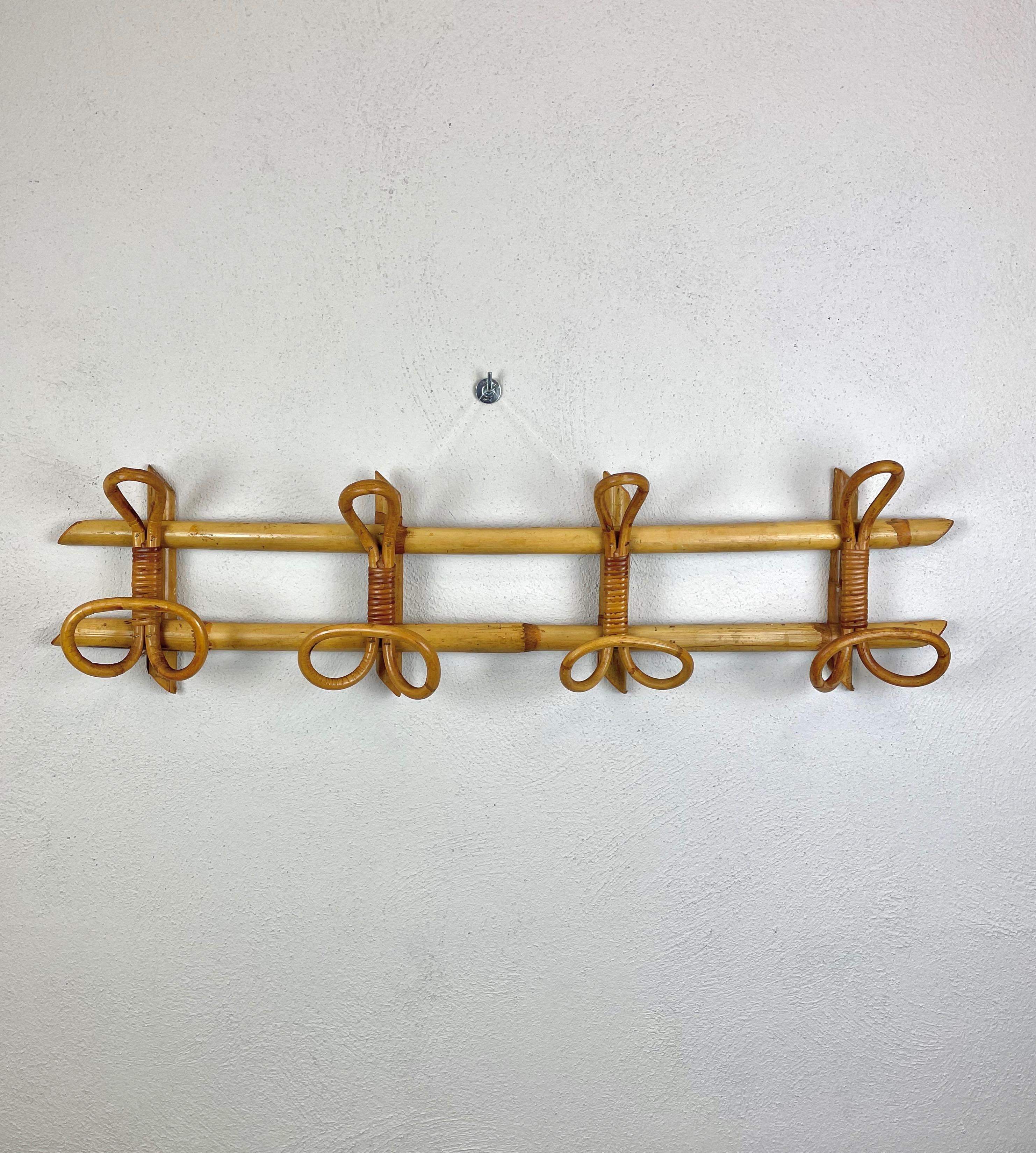 French Riviera mid-century rattan and bamboo coat hanger made in Italy during the 1960s.

This wonderful piece features a structure in bamboo canes and four rattan upper hooks and lower hooks for hanging coats.