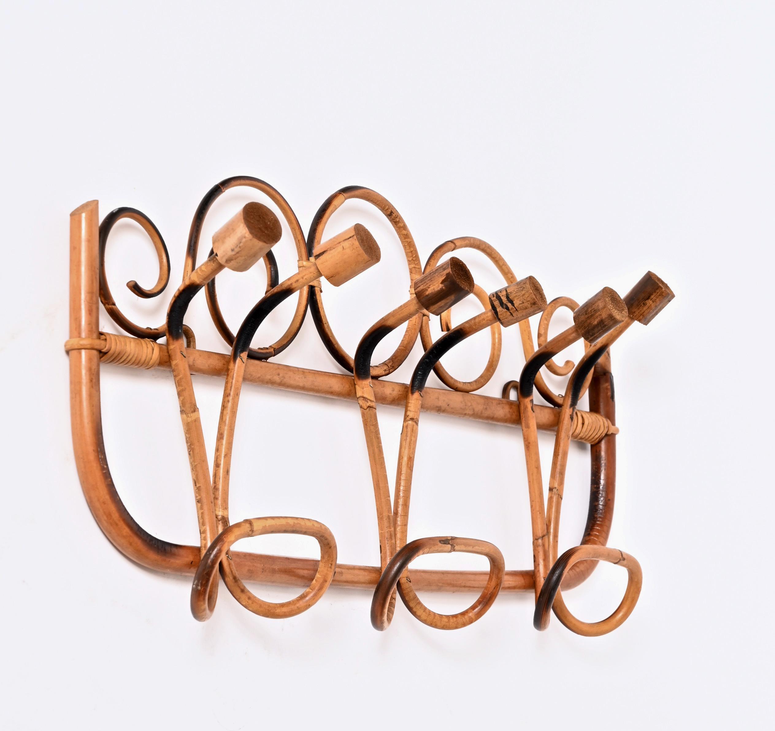 Incredible midcentury coat rack in rattan and bamboo in amazing French Riviera style. This wonderful piece was made in Italy during the 1960s.

This unique piece features a bamboo cane frame with six brown rattan top hooks and three bottom hooks