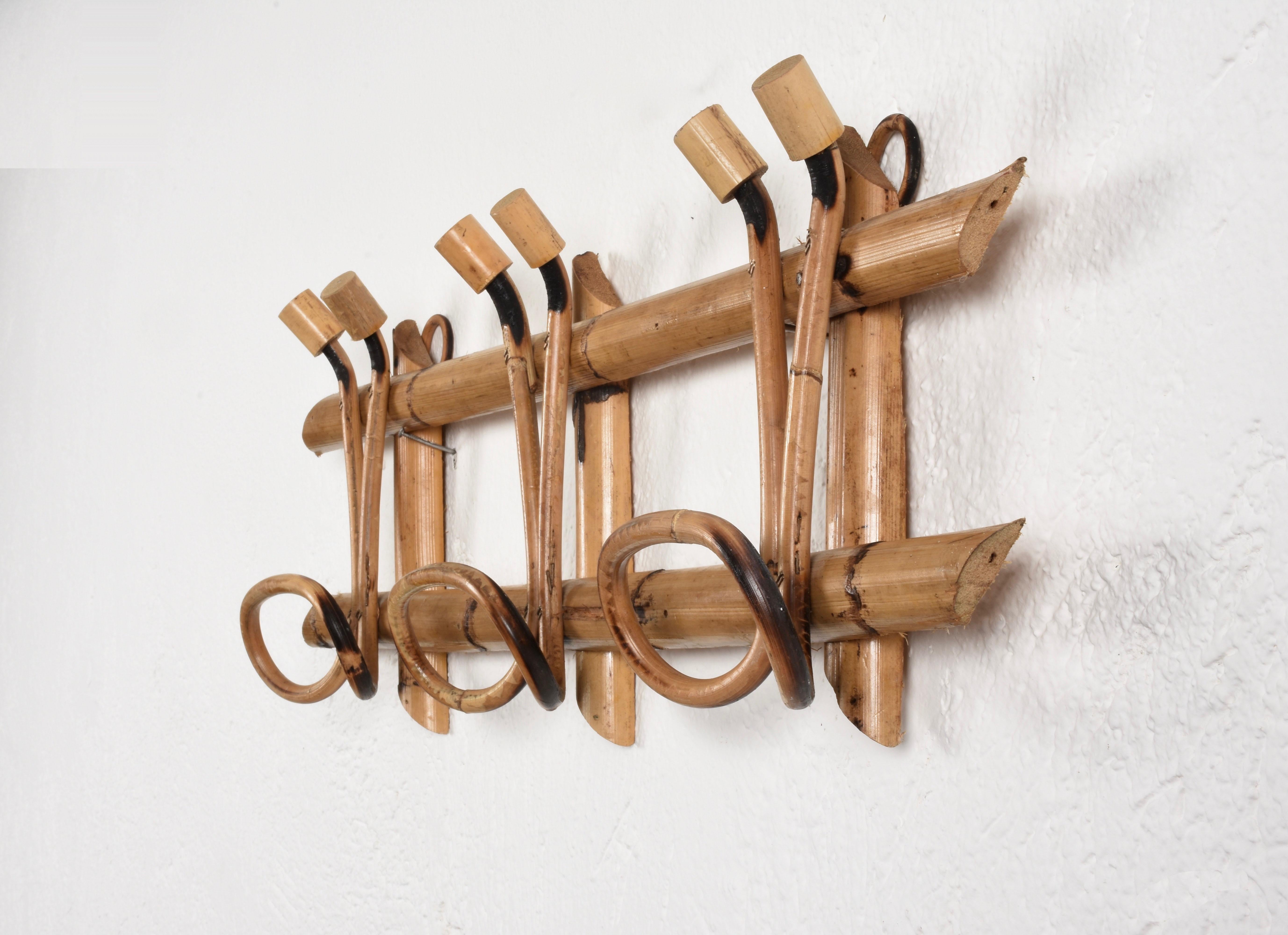 Beautiful midcentury French riviera rattan and bamboo coat rack.

The piece was produced in Italy in 1961 and features three upper hooks and lower hooks for hanging clothes.

An item in wonderful conditions that will enrich a midcentury living