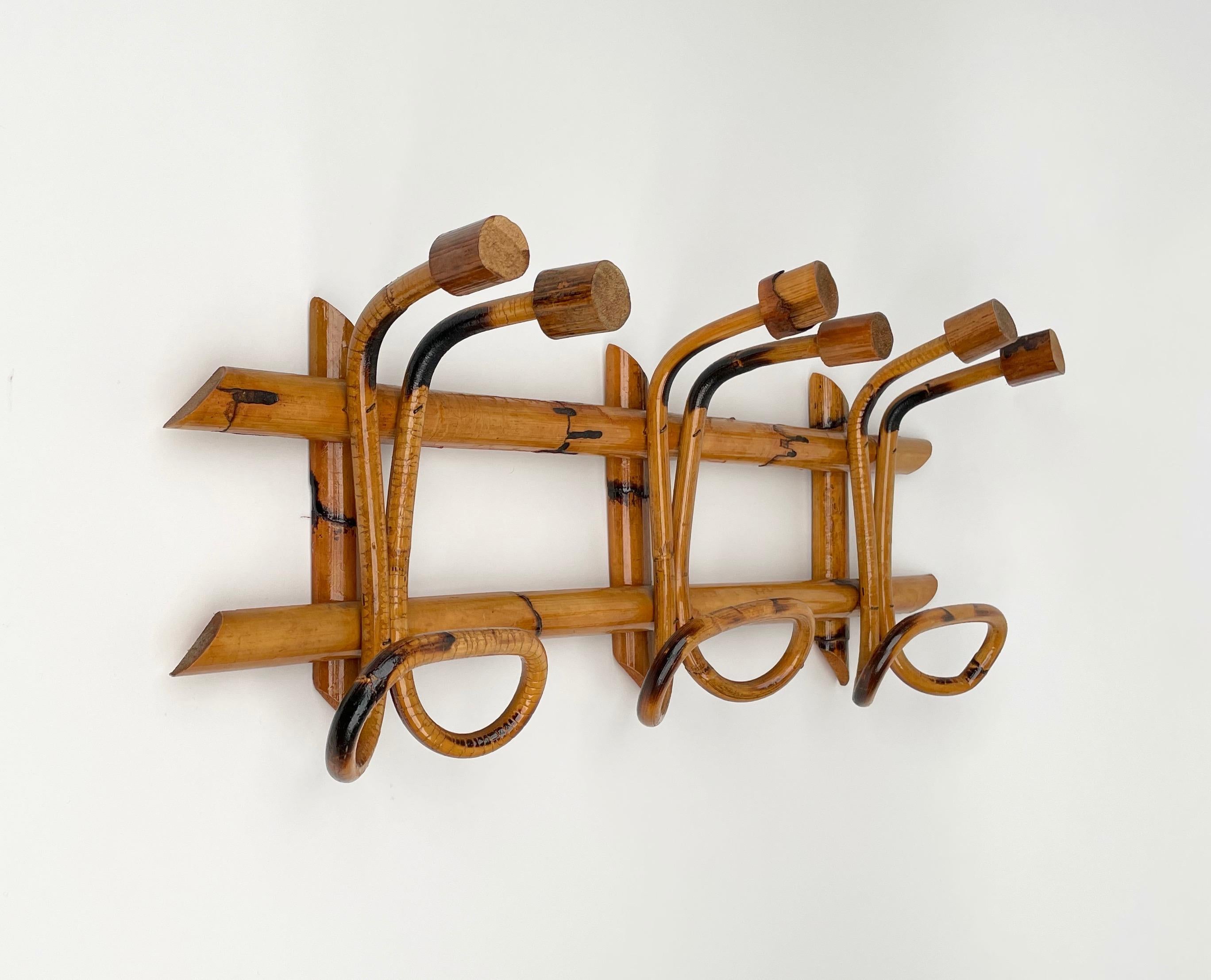This beautiful rattan coat hanger is a French Riviera Midcentury production.

The piece was produced in Italy in 1960s and features a structure in bamboo canes and three rattan upper hooks and lower hooks for hanging clothes.

The simple
