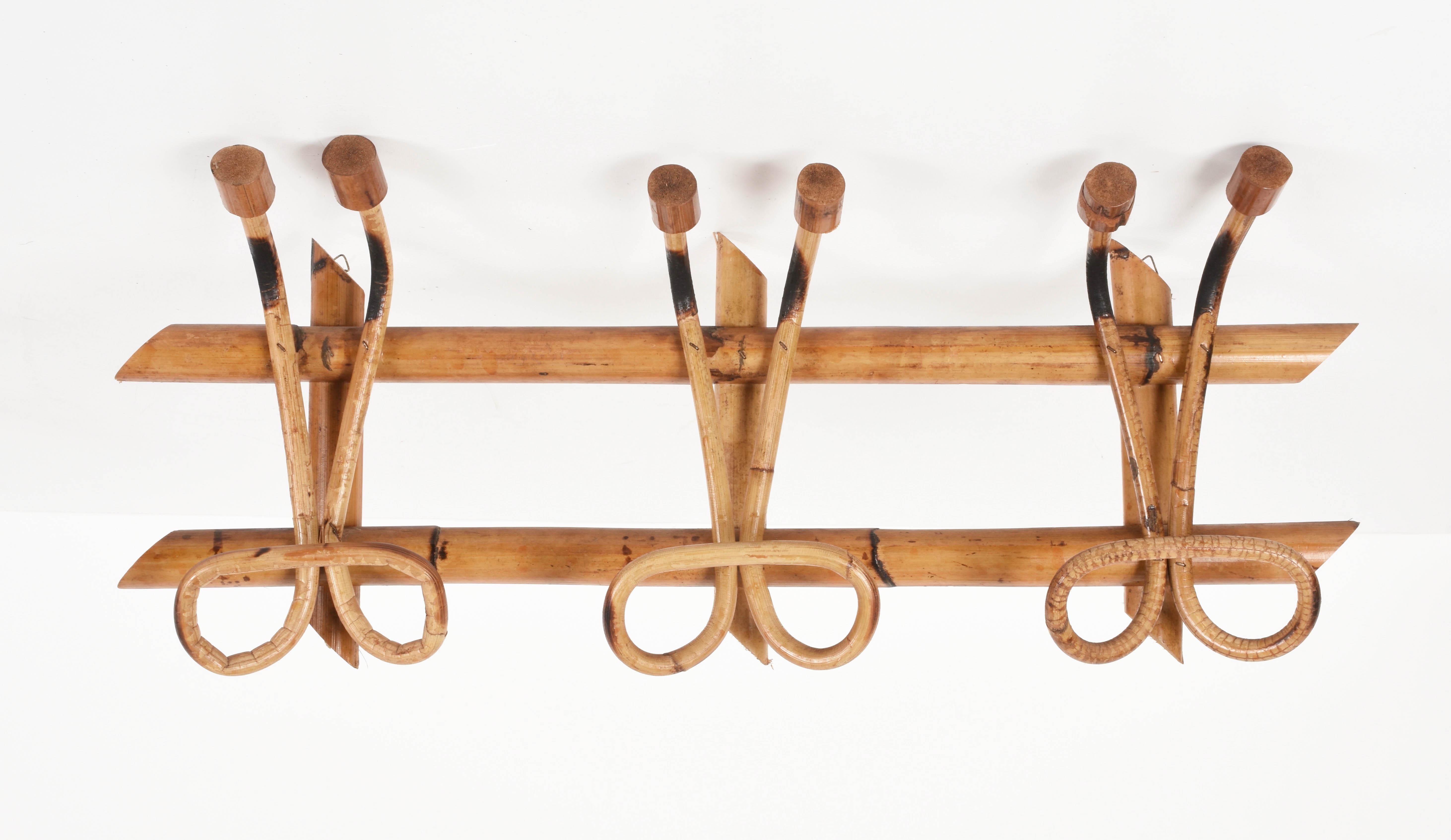 This beautiful rattan coat hanger is a French Riviera Midcentury production.

The piece was produced in Italy in 1961 and features a structure in bamboo canes and four rattan upper hooks and lower hooks for hanging clothes.

The simple elegance