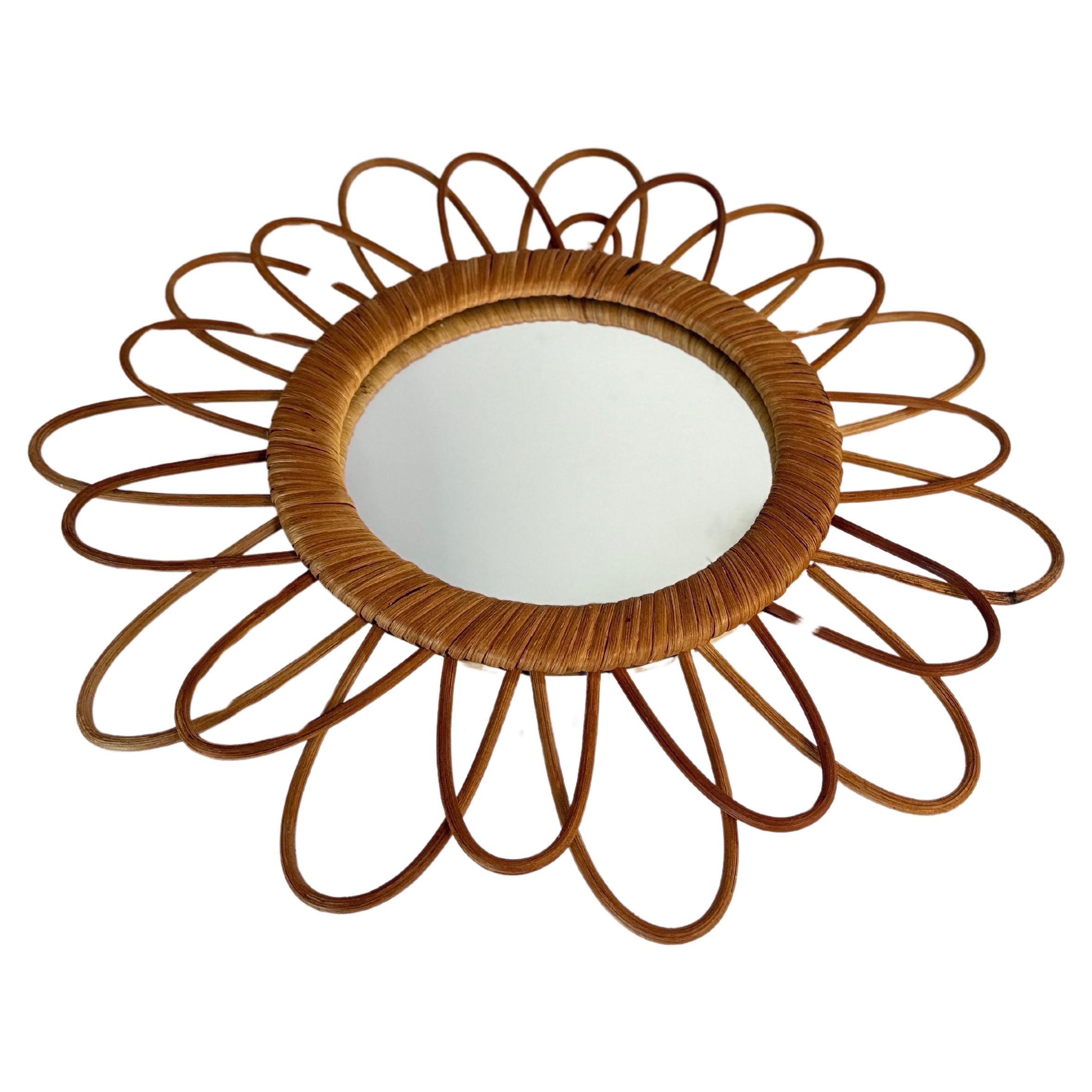 Italian rattan wall mirror (circa 1960s)  Franco Albini style. The mirror has a complex weave of rattan in a series of horseshoe projections on the edge of the frame. There is a lovely aged patina on the rattan; the glass is intact.