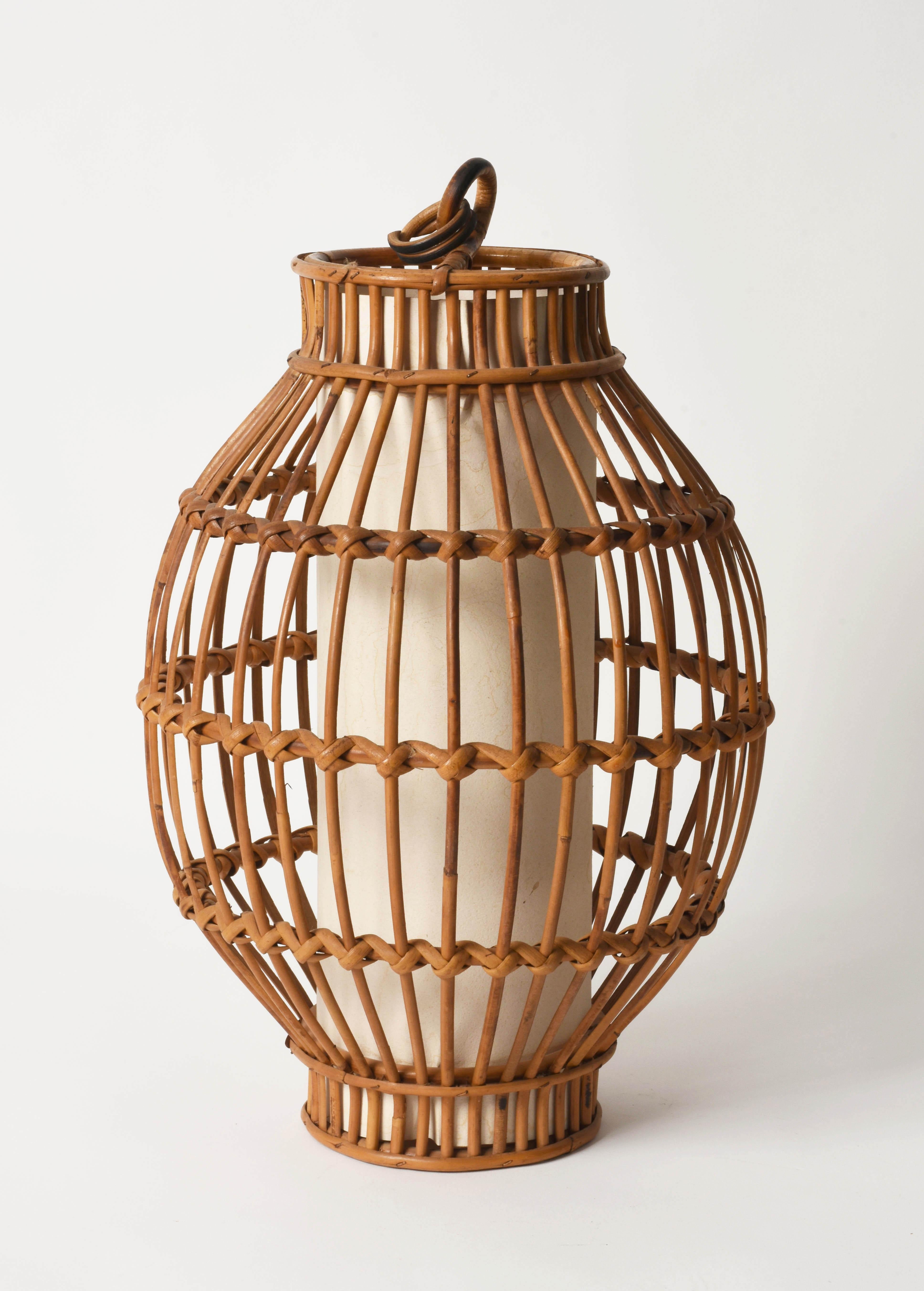 Wonderful rattan pendant with a white central cylinder chandelier in French Riviera style, produced in Italy during the 1960s.

Its design is perfect for who loves the use of rattan to create wonderful pieces.

This chandelier is perfect for a
