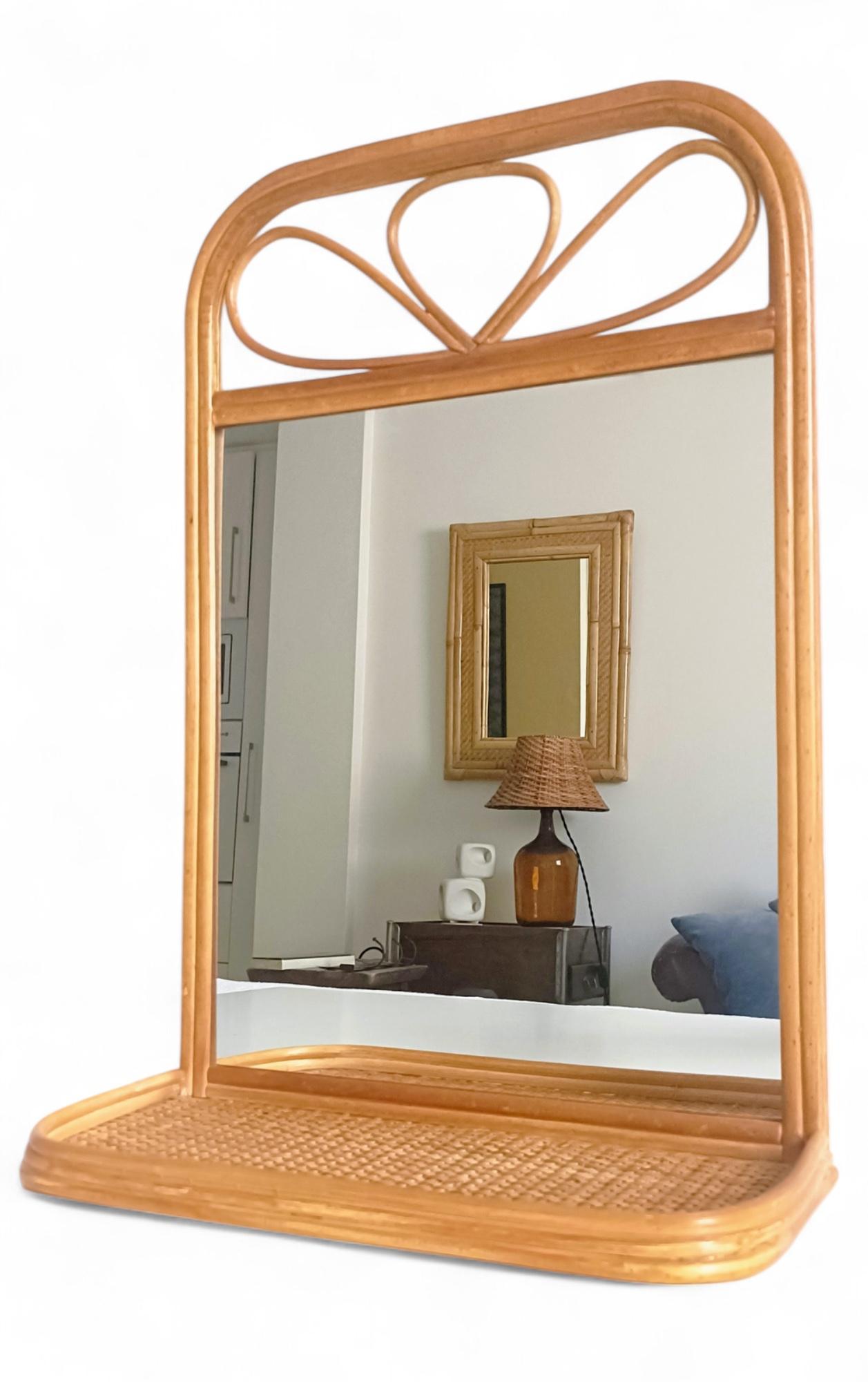 French Riviera Style Rattan and Wicker Mirror with Shelf, Spain, 1960s–70s

Charming small wall mirror in woven rattan, wicker, and wood, handmade in Spain circa the 1960s–70s. The piece features a gently curved decorative top and a small built-in