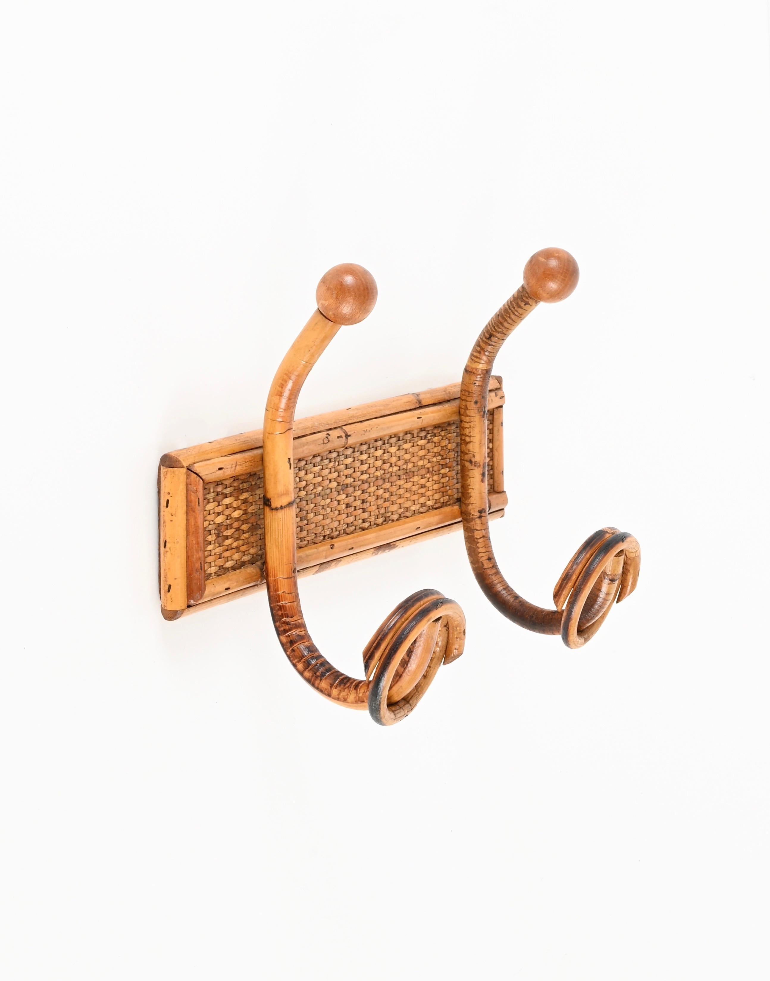 Splendido appendiabiti in stile Costa Azzurra realizzato in rattan curvo, vimini intrecciato, bambù e legno di noce. Questo grazioso appendiabiti biologico è stato realizzato in Italia negli anni '60.  

Questo esclusivo appendiabiti a due ganci