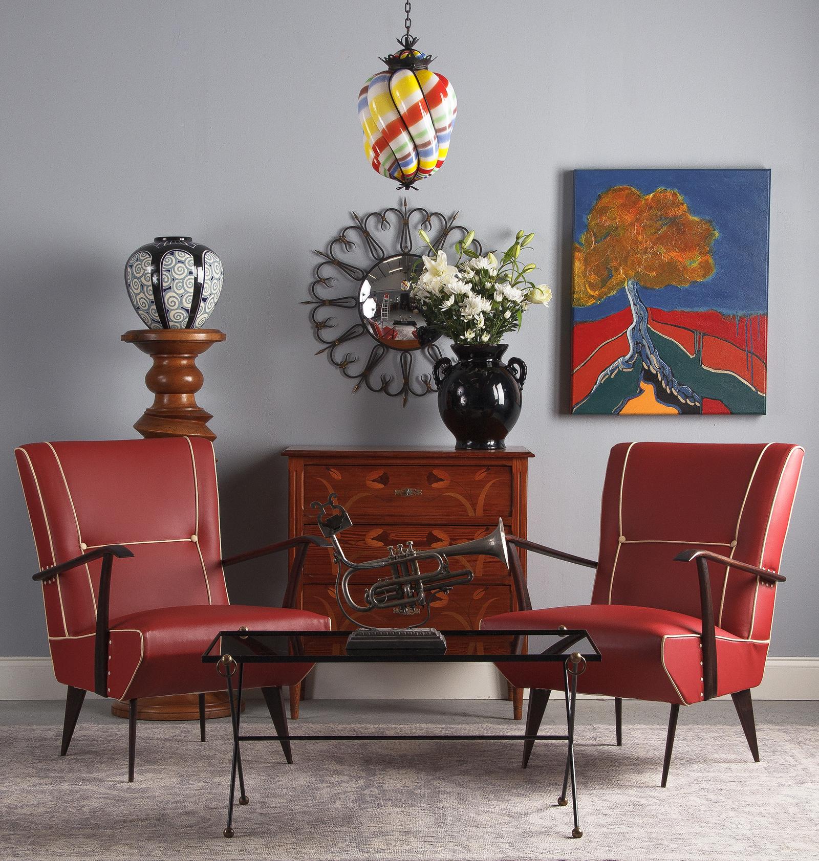 A vintage convex round mirror set in a shapely wrought iron sunburst style frame with brass adornment, French, circa 1950. Elongated loops stemming from the mirror curl out and over to form a lovely repeating scalloped motif. The curls are bound by