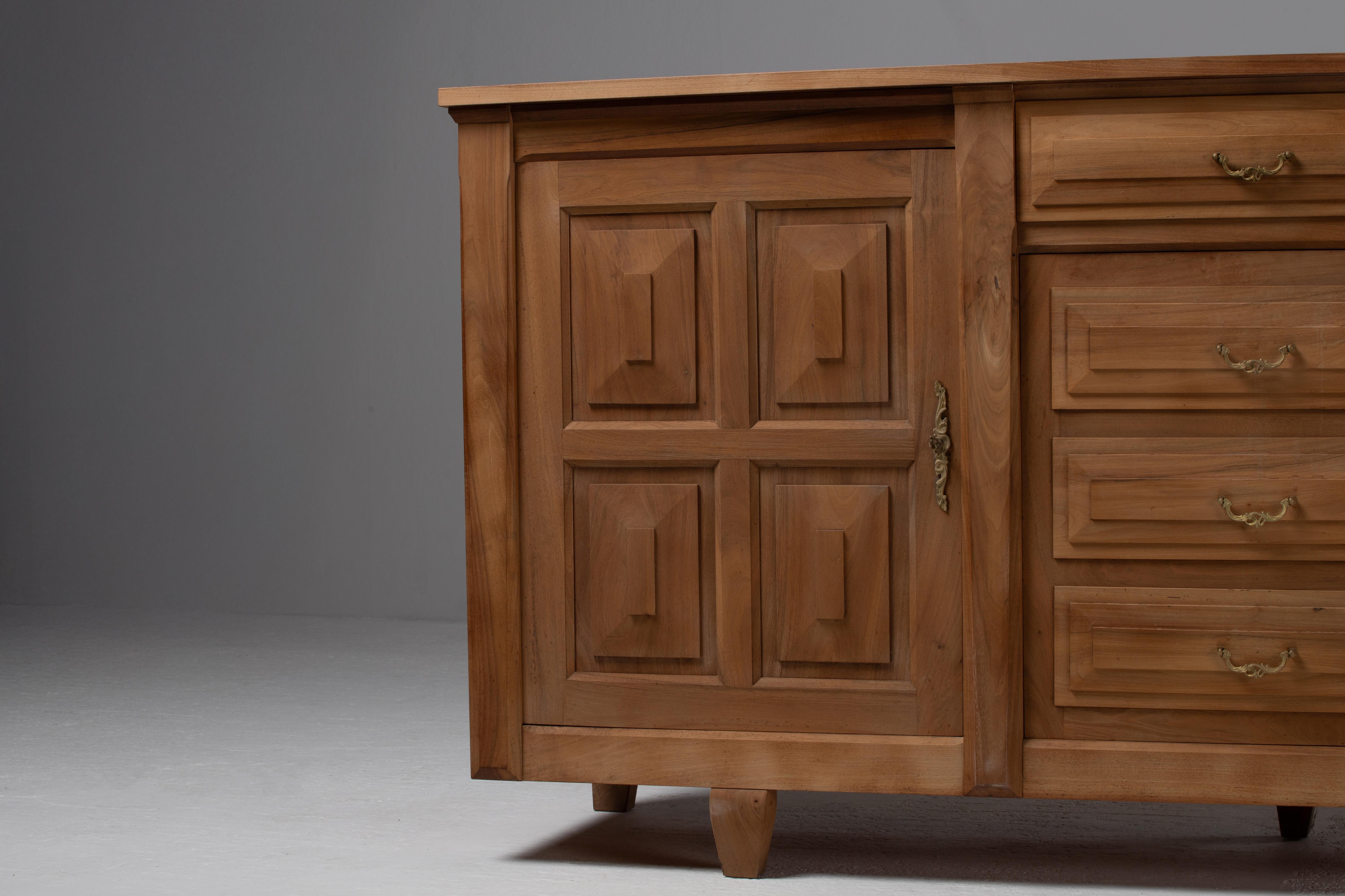 Con la sua sorprendente facciata geometrica e la sua materialità grezza, questa credenza brutalista francese degli anni '50 è una testimonianza dell'arte scultorea del design di metà secolo. Realizzata in legno massiccio di quercia, la sua