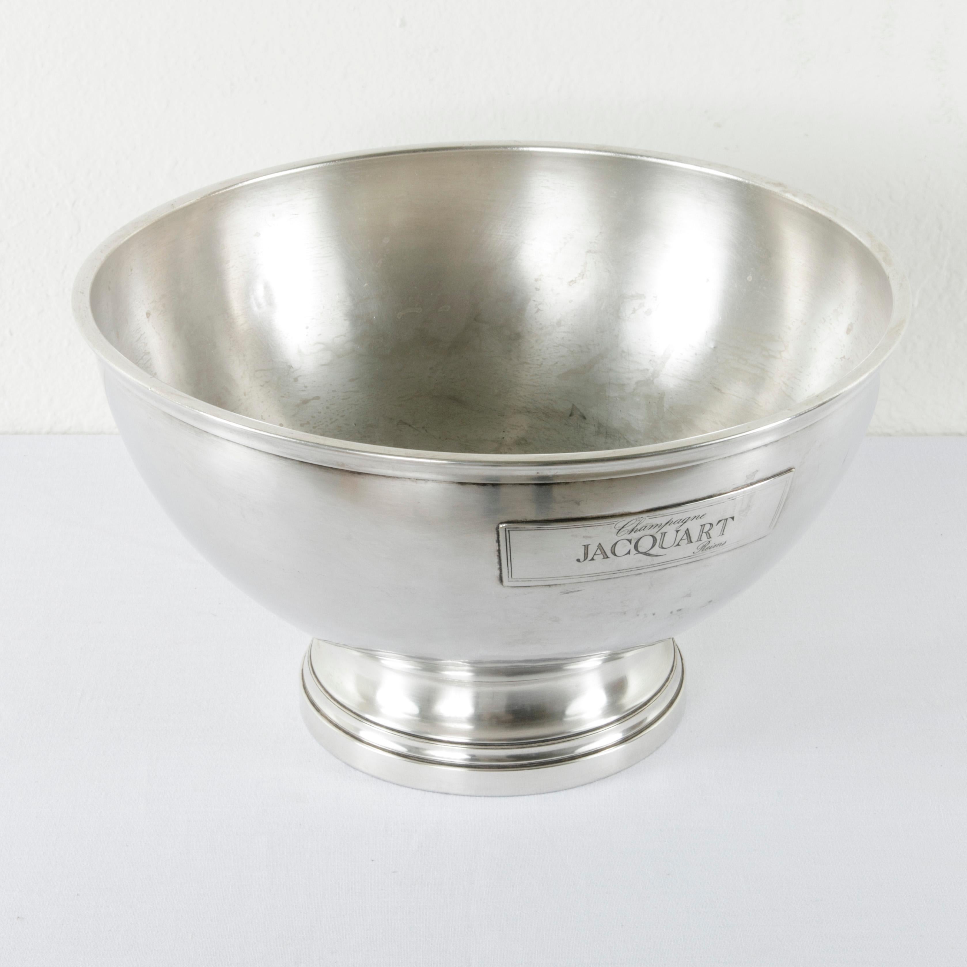 This large midcentury French silver plate hotel champagne bucket features a label on both sides with the name of the champagne producer, Jacquart, and the city of origin, Reims, in the Champagne region of France. A silver plate hallmark with a
