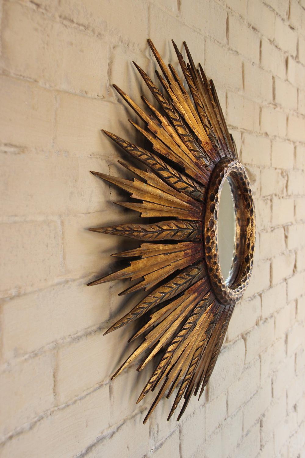 A midcentury French sunburst mirror, circa 1930 with feathered rays. Original mirror plate. The mirror is 6.5 inches in diameter.