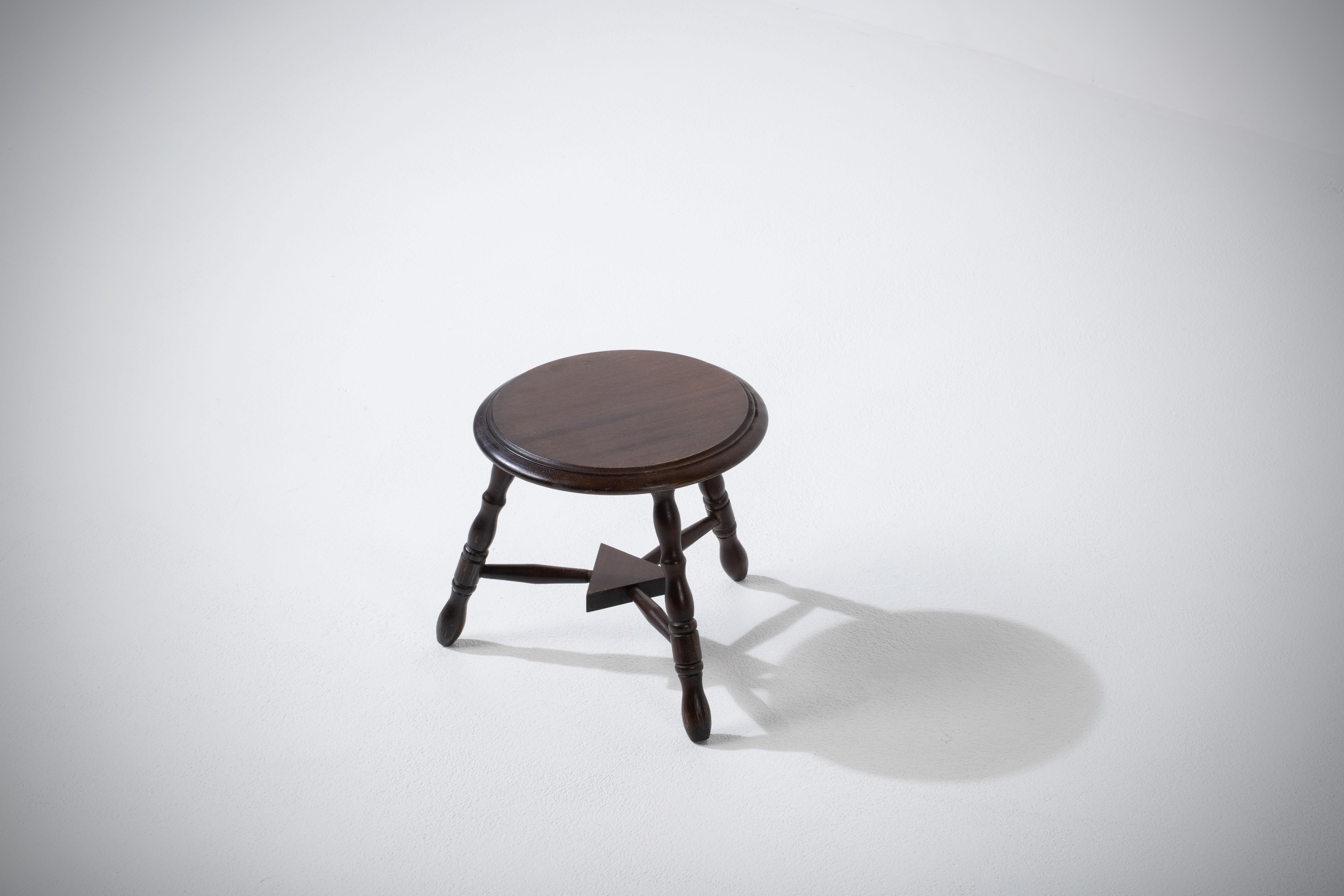 Introducing a fantastic midcentury wooden stool, crafted in France during the 1960s. This piece is constructed without the use of hardware, boasting an elegant round seat, flared legs, and intricate gouge work, all made from walnut.

The design is