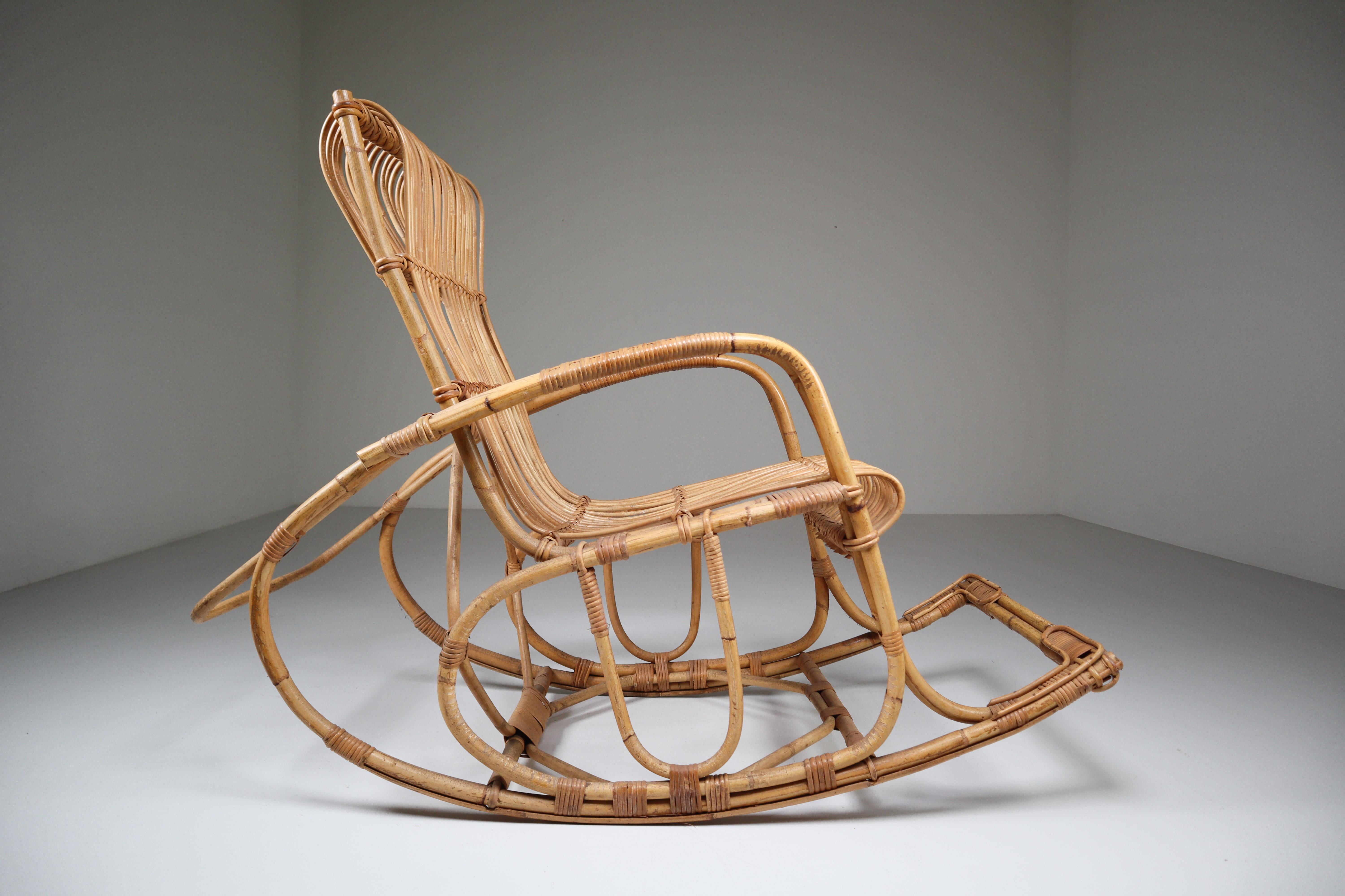 Midcentury French rattan rocking chair and features a steam bent bamboo frame. This rare rocking chair was made in the late 1960s. Great curves and good original condition.
