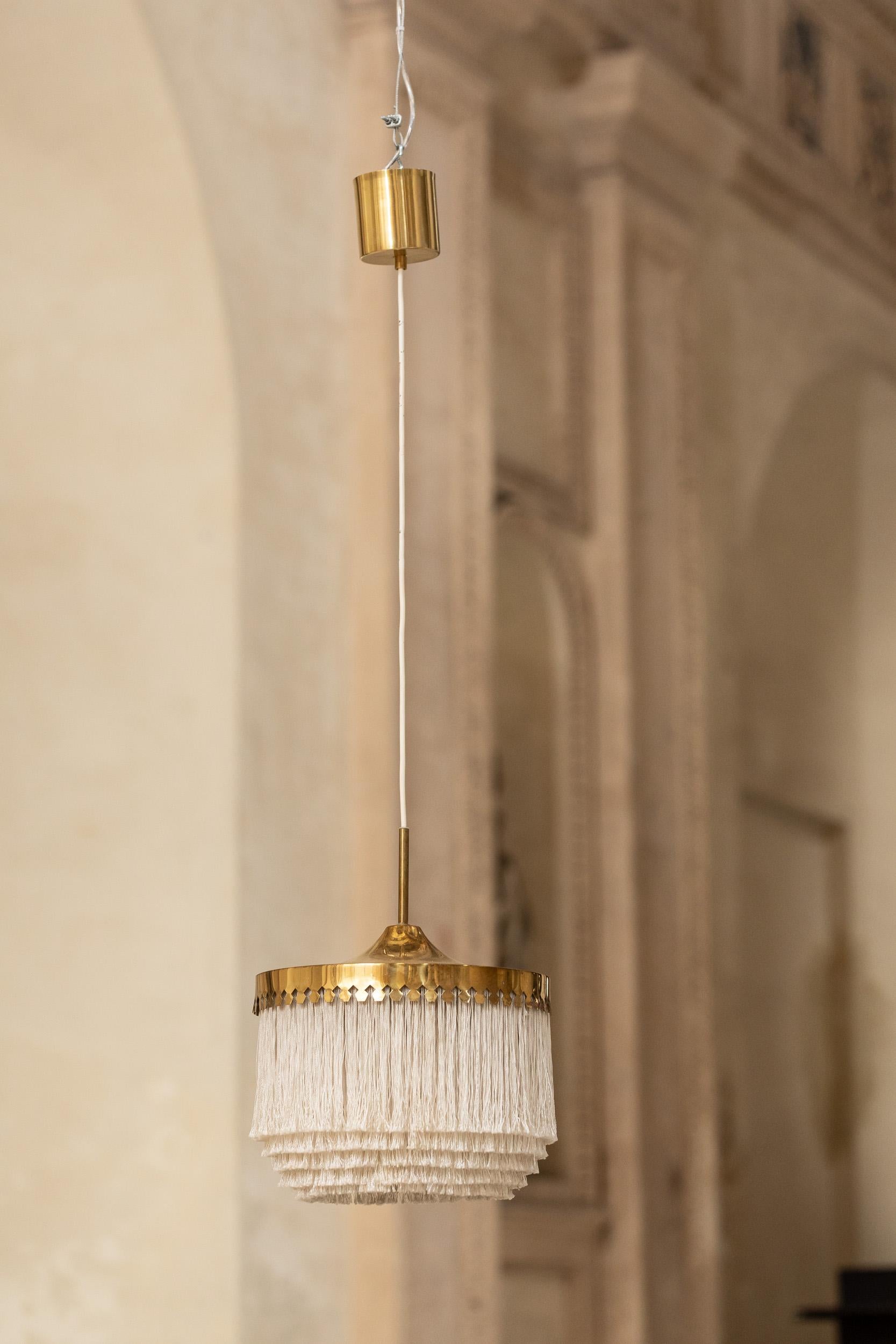 Iconic fringe pendant light by Hans Agne Jakobsson.
Beautiful fabric fringes in neutral color and gold brass decoration

