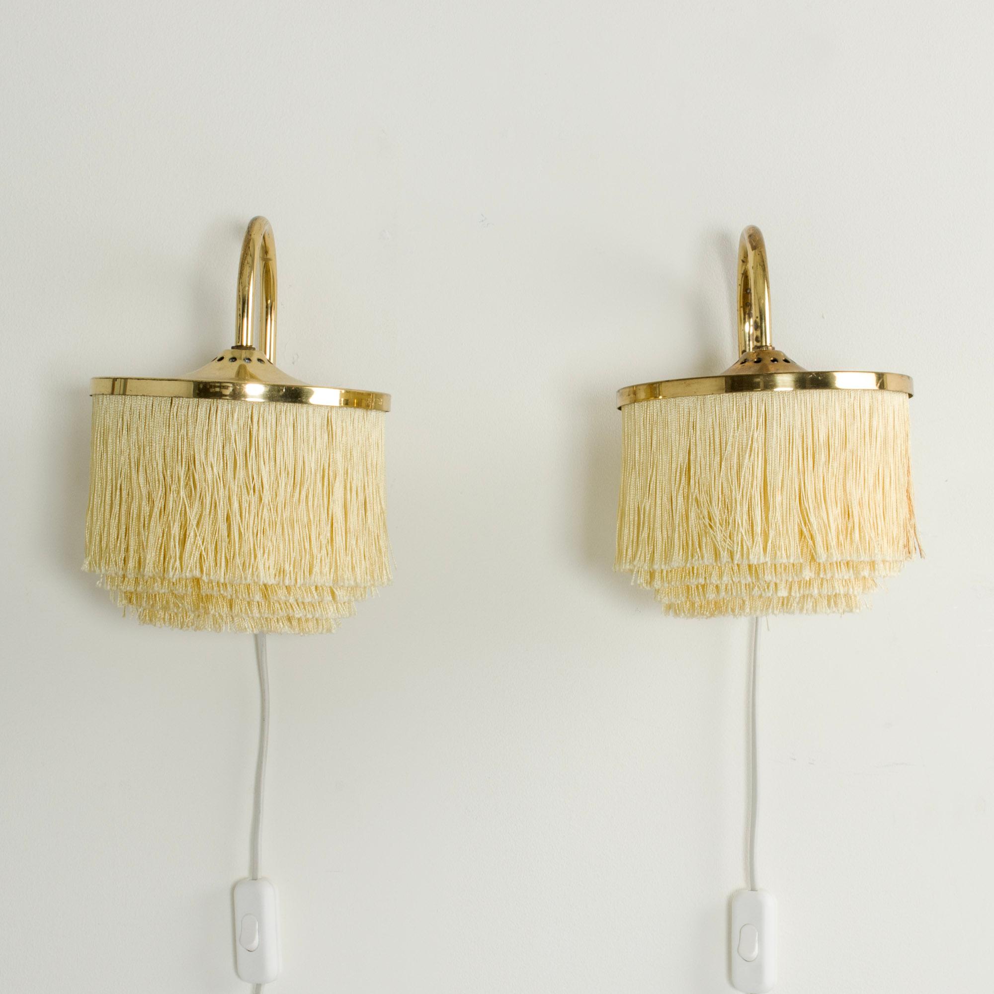 Pair of “Fringe” wall lights by Hans-Agne Jakobsson, made from brass. Drapes of textile chords are suspended in layers from shade. Great mood light.
