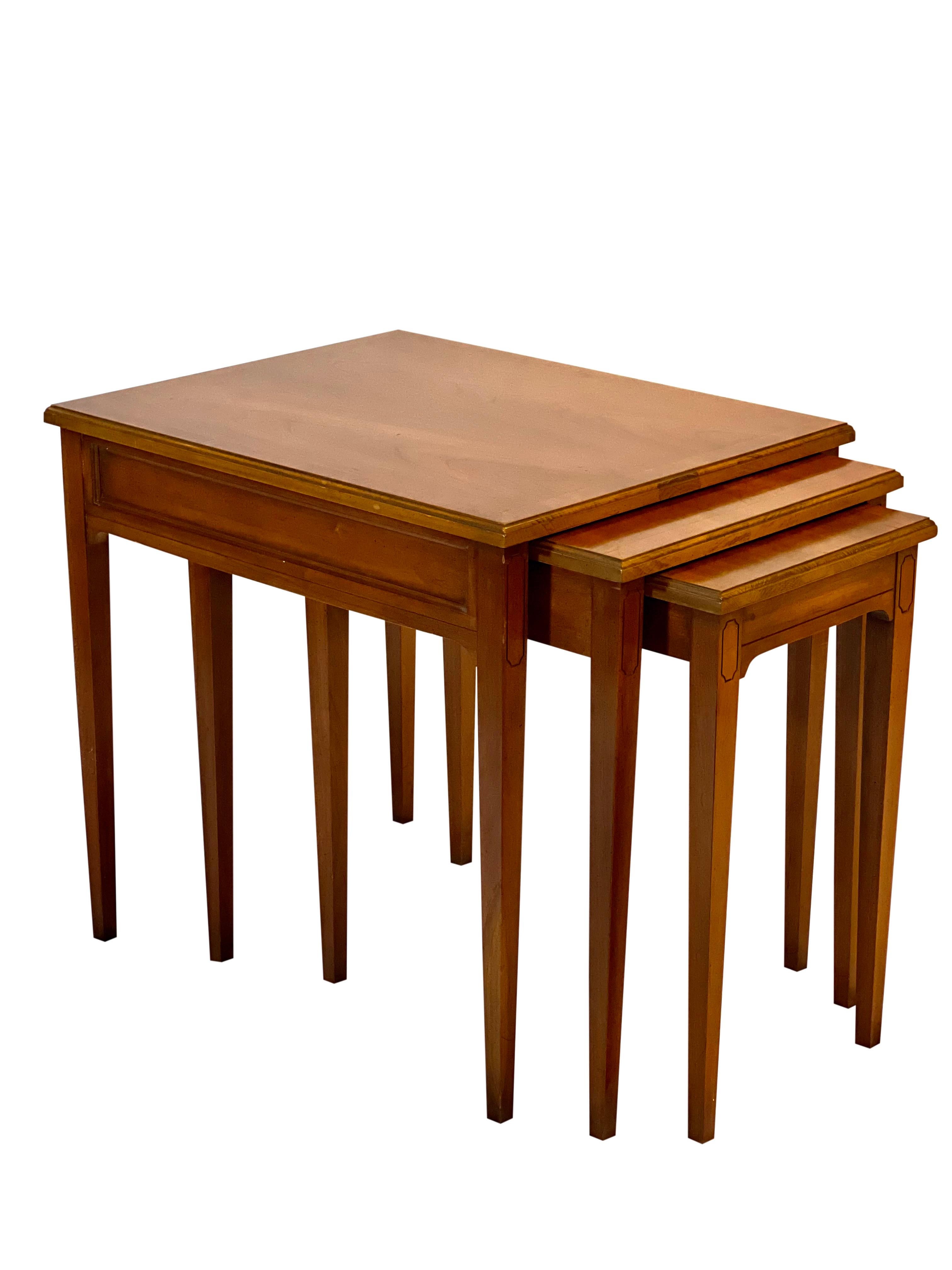 Midcentury fruitwood nesting tables by Heritage, set of 3.

Beautifully crafted tables in near mint condition. The set meticulously fits together with built-in sliding rails which not only protect but also keep the tables perfectly aligned. They