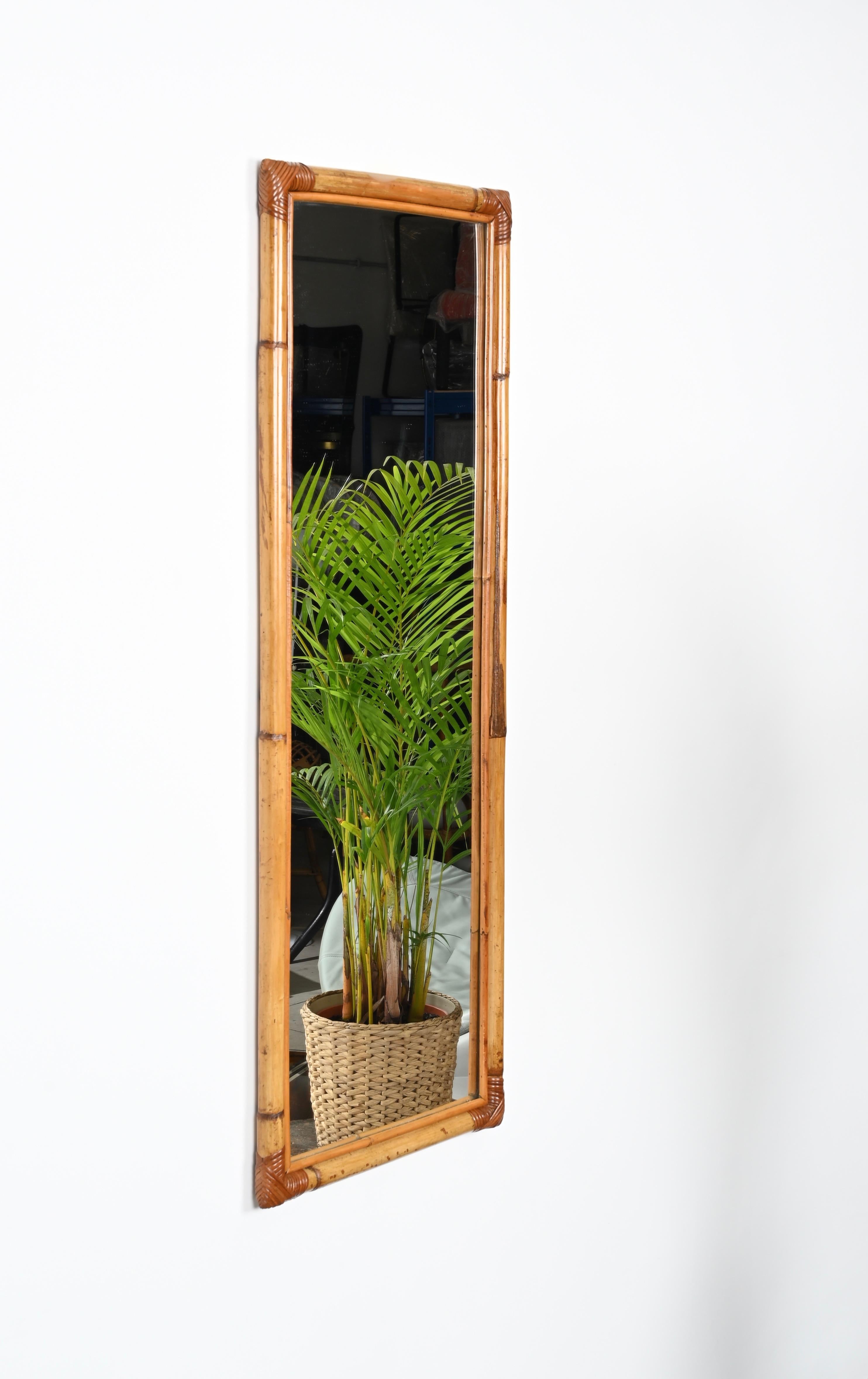 Gorgeous rectangular full-length midcentury mirror in bamboo and hand-woven wicker. This elegant organic mirror was designed in Italy during the 1970s. 

This sturdy mirror has a wonderful double frame in bamboo with the corners decorated with a