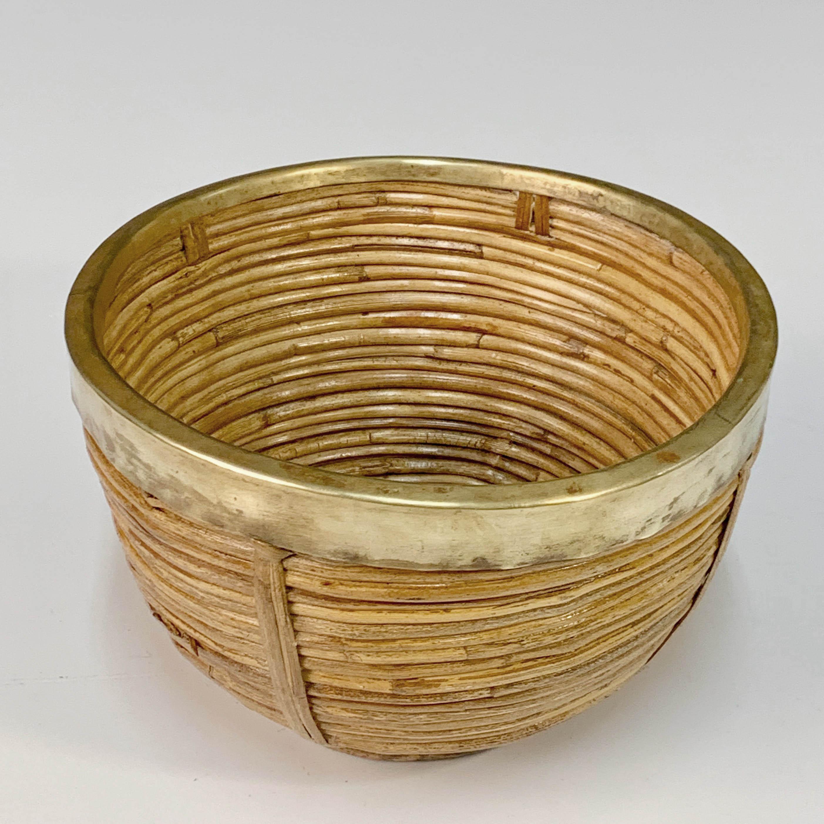 Mid-Century Modern bowl, centrepiece or basket in bamboo and rattan with a brass coating that covers the upper part.

Handcrafted in Italy during the 1970s in the style of Gabriella Crespi. It can be used as a fruit bowl or centerpiece to add an