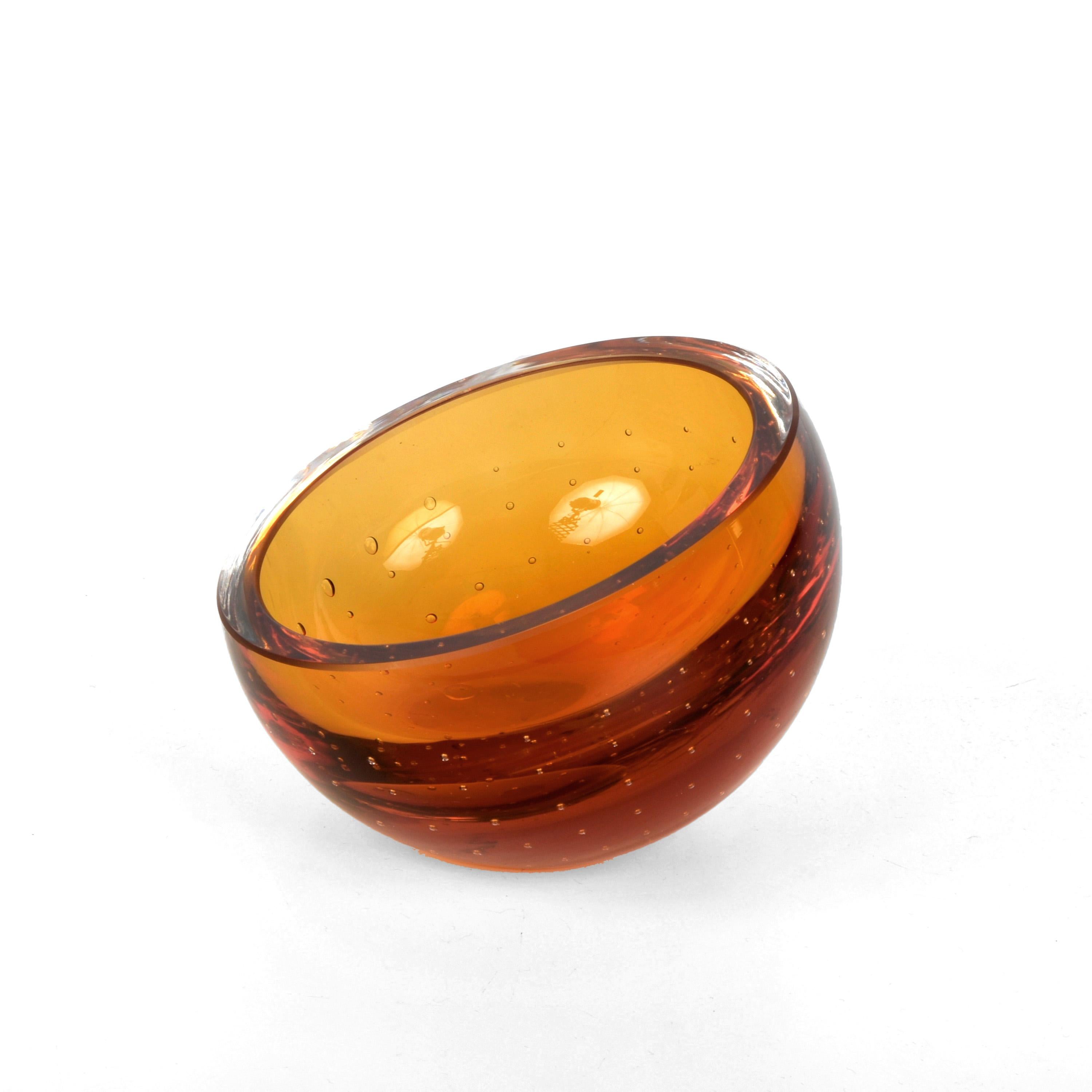 Spectacular mid-century decorative bowl in amber Murano glass with air bubbles (bullicante). This wonderful piece was produced in Italy in the 1960s and is attributed to Galliano Ferro.

This piece is unique for the elegant mix of peculiar