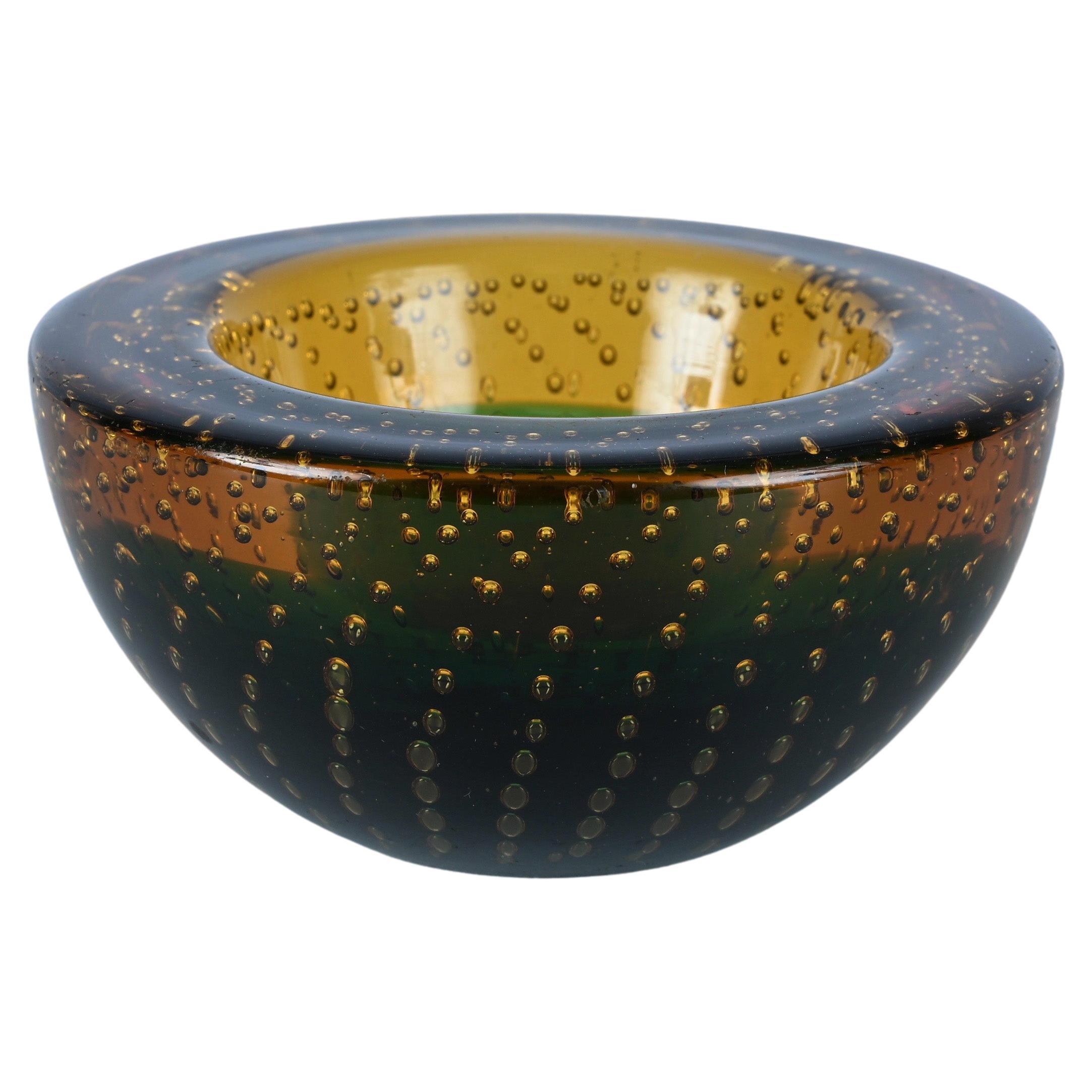 Spectacular mid-century decorative Murano Art glass bowl in dark amber, yellow, green and blue Murano glass with air bubbles (bullicante). This incredible piece was produced in Italy during the 1960s and it is attributed to Galliano Ferro.

This