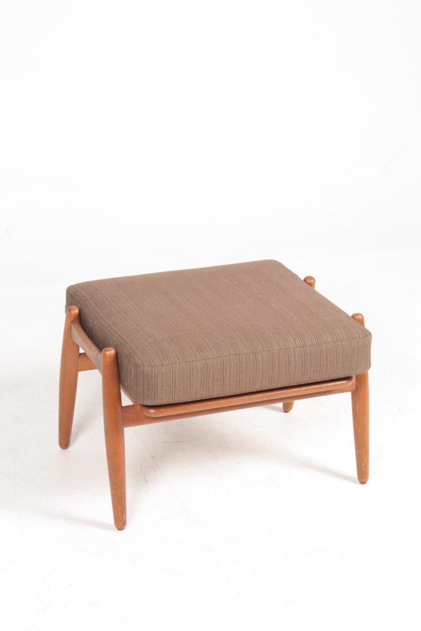 Ottoman in oak with fabric seat, designed by Maa. Hans J. Wegner and made by GETAMA Denmark. Great original condition.