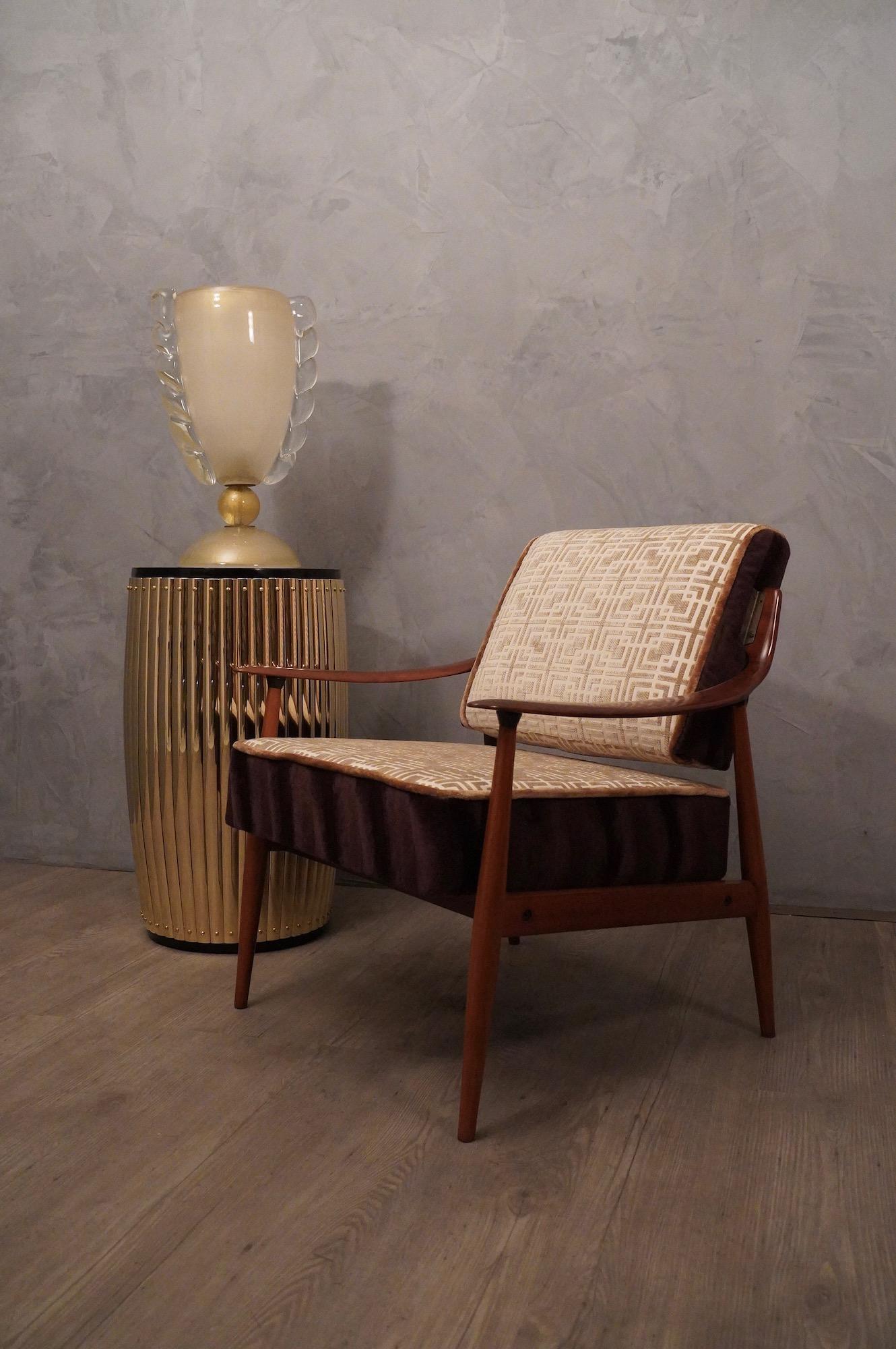 Poltrona in stile classico italiano, in legno e con un'elegante imbottitura in velluto con disegni geometrici. Nota la forma dei montanti laterali dello schienale e il profilo dei braccioli.

Poltrona composta da una struttura in legno di faggio