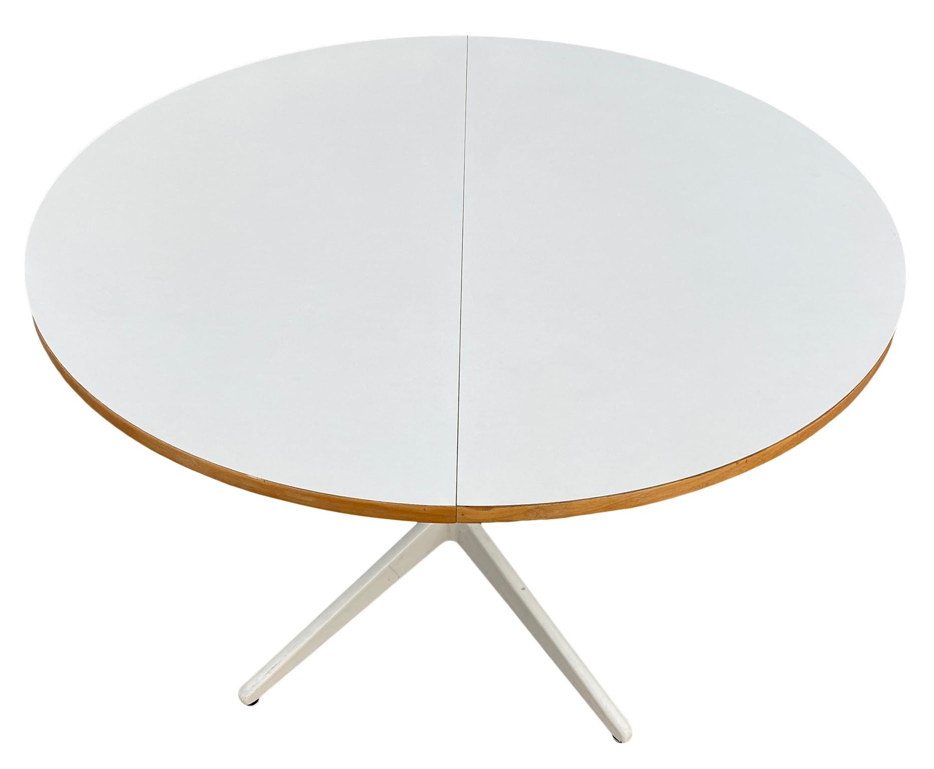 Rare Mid-Century Modern American George Nelson for Herman Miller expandable round dining table. Beautiful White Laminate table top. Solid Powder coated metal table base. Made circa 1960. Original White Laminate top with maple veneer sides in good
