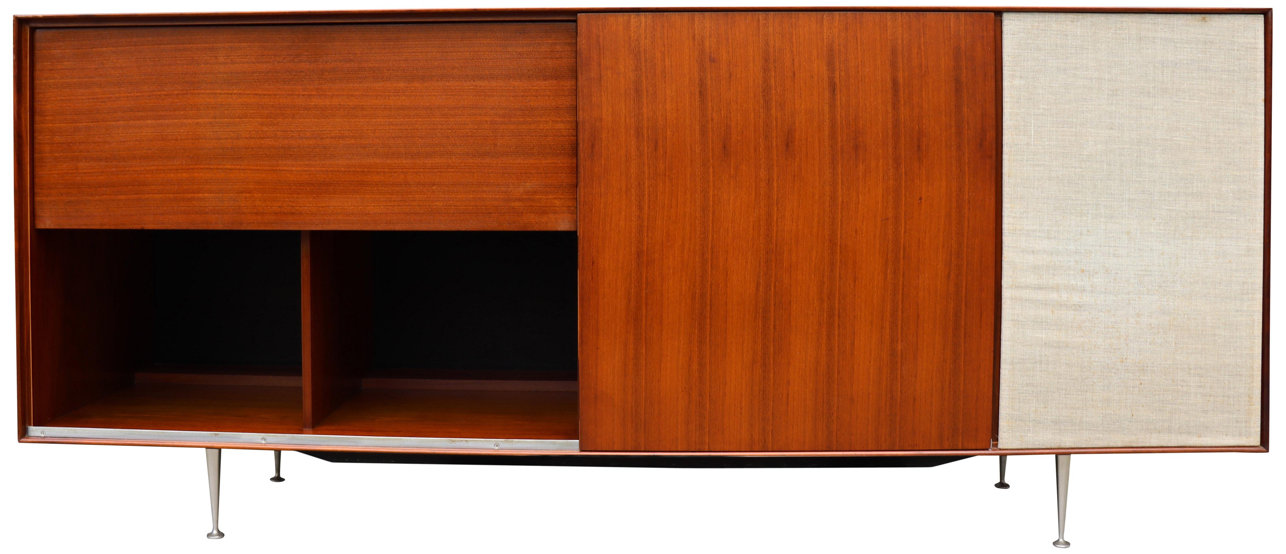 For your consideration is this amazing Hifi cabinet designed by George Nelson for Herman Miller. Featuring walnut on the signature cast aluminum legs. Having one adjustable shelf on the right sliding door, one adjustable shelf and one pull-out shelf