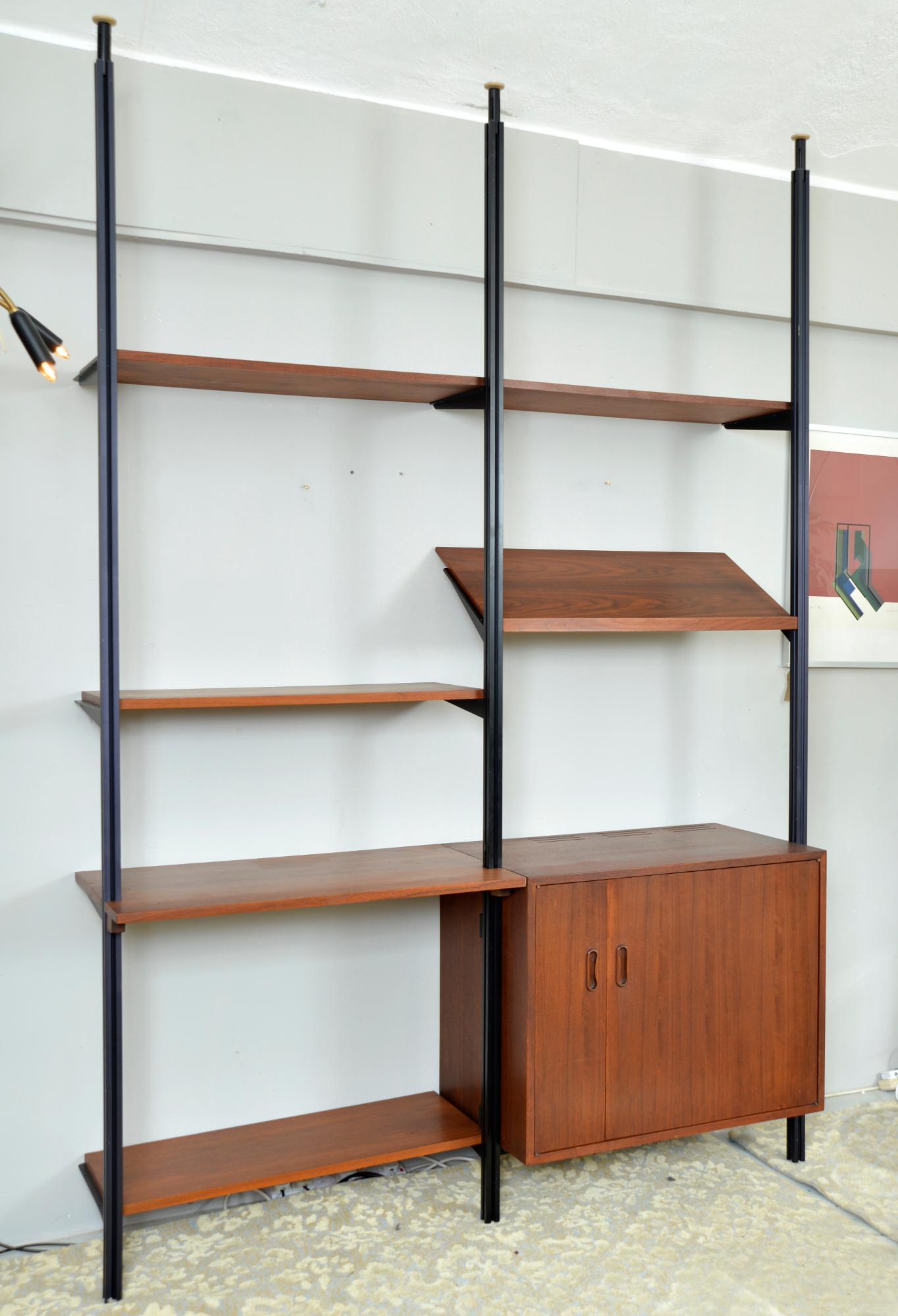 Dies ist ein seltenes amerikanisches, modulares, freistehendes 'Omni'-Regalsystem aus Nussbaum und Aluminium, entworfen von George Nelson im Jahr 1952 und hergestellt von Herman Miller, Amerika. 
Das Regalsystem ist mit federbelasteten Spannstangen