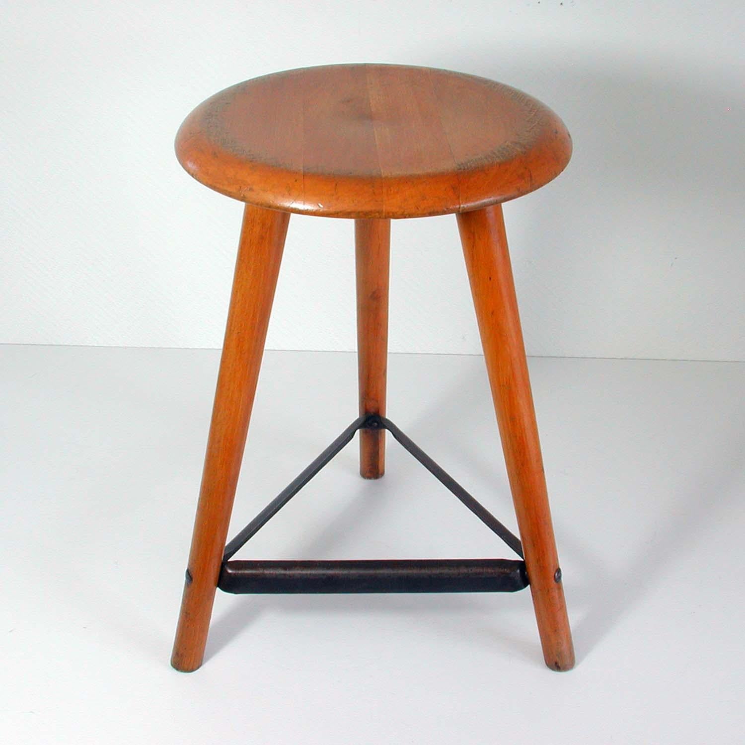 This vintage Industrial work stool was manufactured in Germany in the 1950s by AMA Schemel. It is made of beechwood and iron. The stool has been carefully restored.