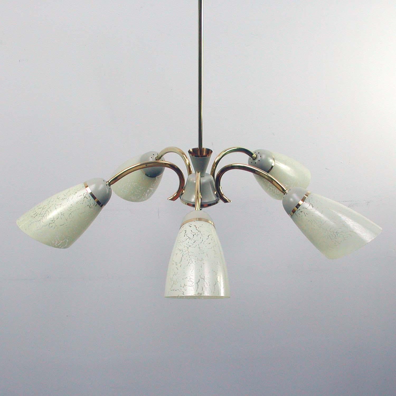 This German five armed sputnik chandelier from the 1950s is made of brass and grey lacquered metal and has got 5 cream glass lamp shades. The lamp works on 220V as well as 110V and requires standard E14 Edison screw on bulbs. The lamp is in a very