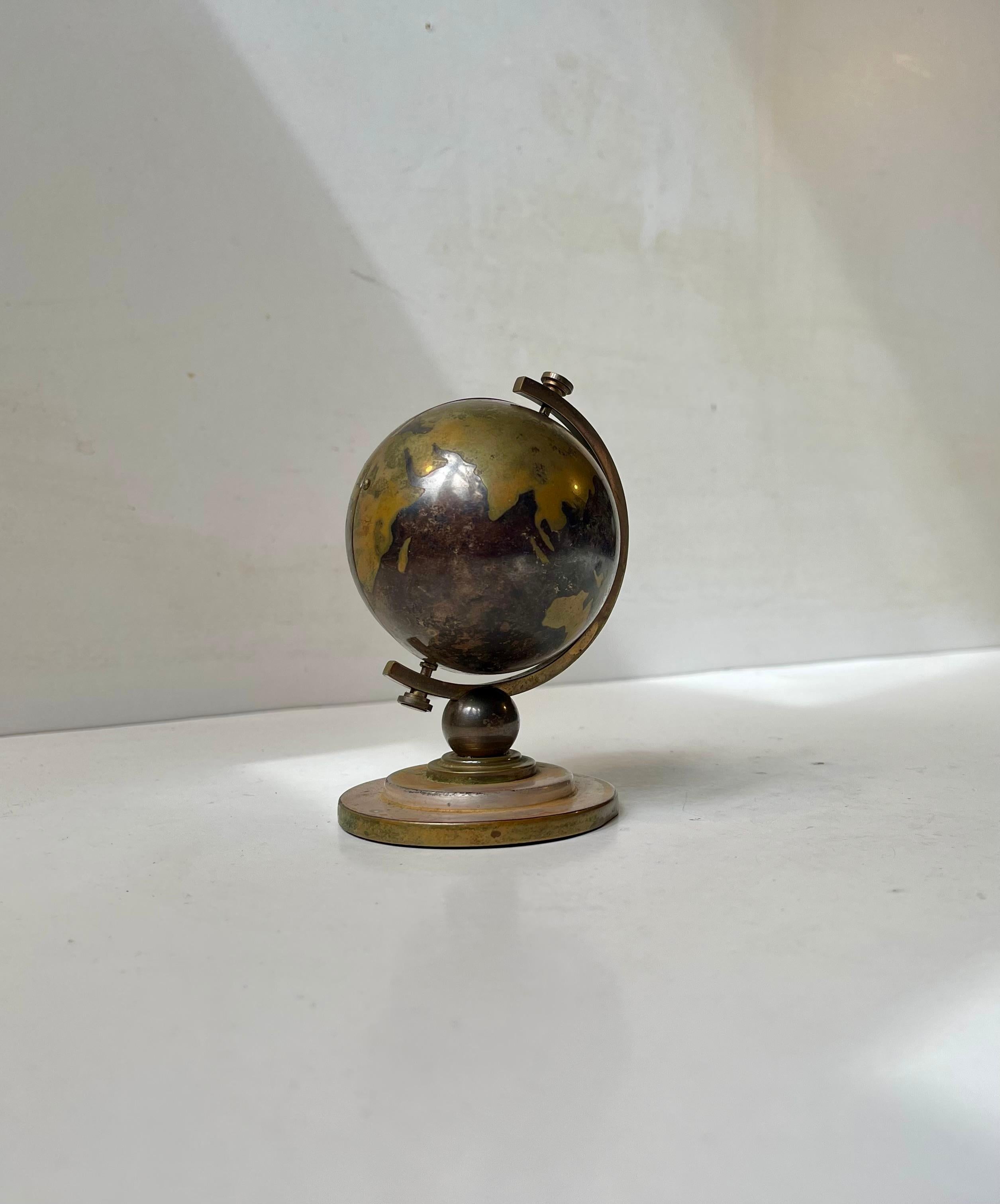 Unusual World globe desk clock in brass. Made by Europa in Germany, circa 1960s. It has a 7-jewels mechanical movement and is working well. We believe it has an alarm as well. It measures 11 cms in height and is 8 cms wide. The globe opens up to