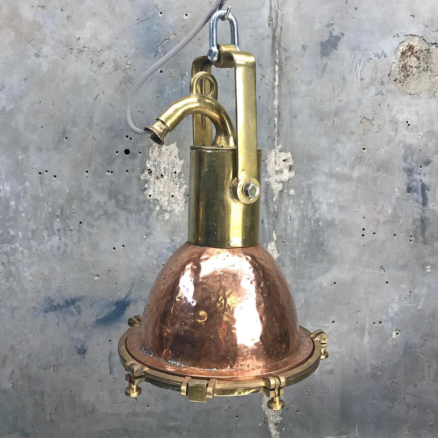 A beautifully aged cargo ships copper and brass pendant lamp restored and ready for installation.

These lights were made in the 1960s in Germany and used to light cargo bays of sea going vessels travelling across the globe.

The main dome is