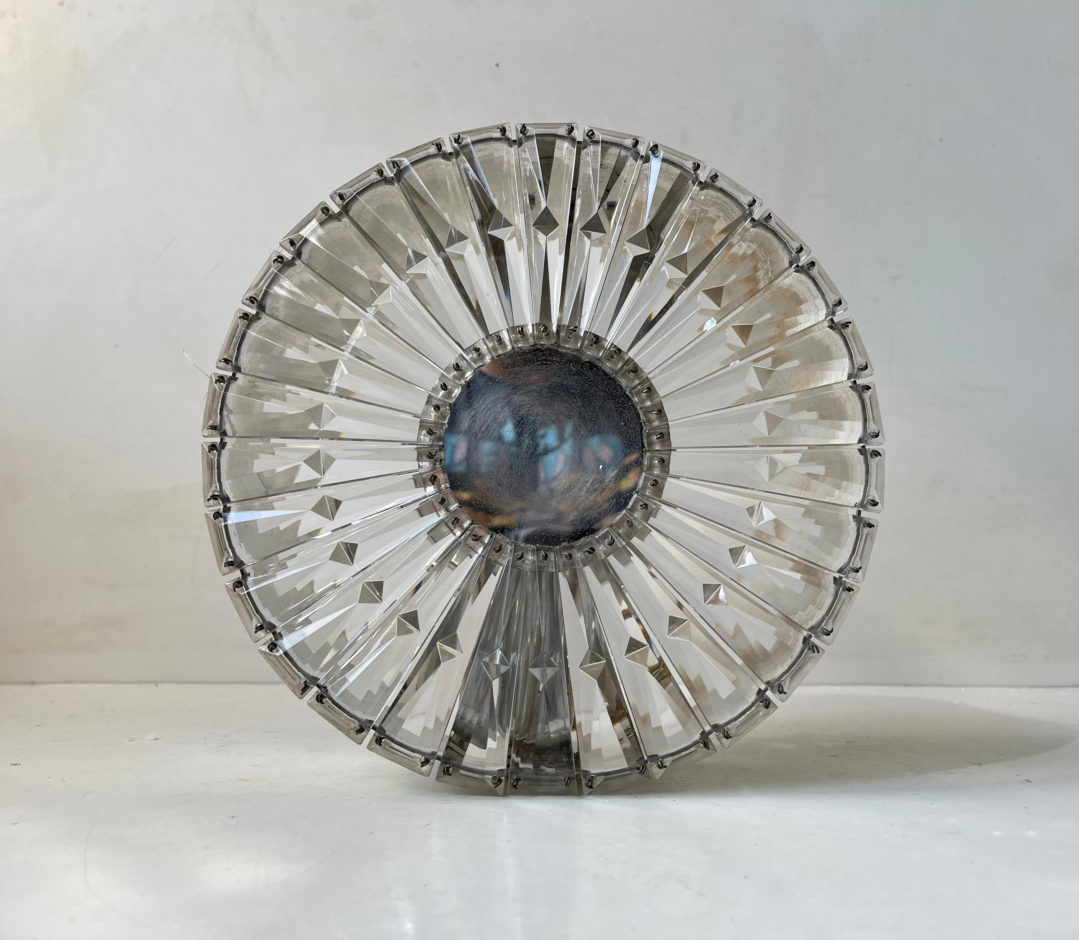 Ornate wall sconce or Flush mount from Glashütte Limburg in Germany. Made during the 1960s. Its made from cut faceted clear crystal glass wire-set on a chromed base. It features a small center mirror. It is to be screwed onto the wall or ceiling.