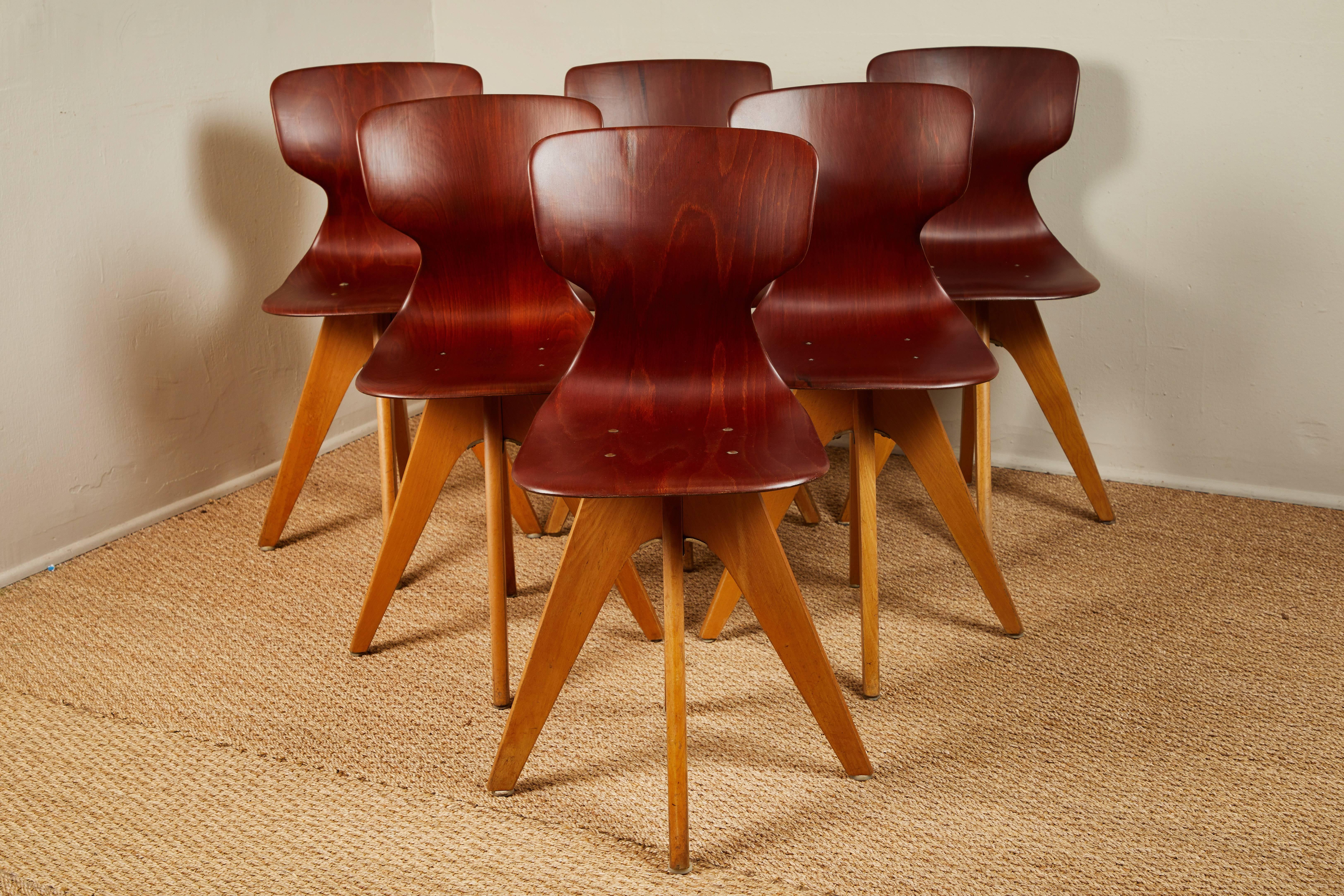 Six molded wood chairs. Used in German schools and universities midcentury. They have a comfortable lumbar curve. Show a little wear and some are slightly different. See images 4 and 5.  Sold individually.
 