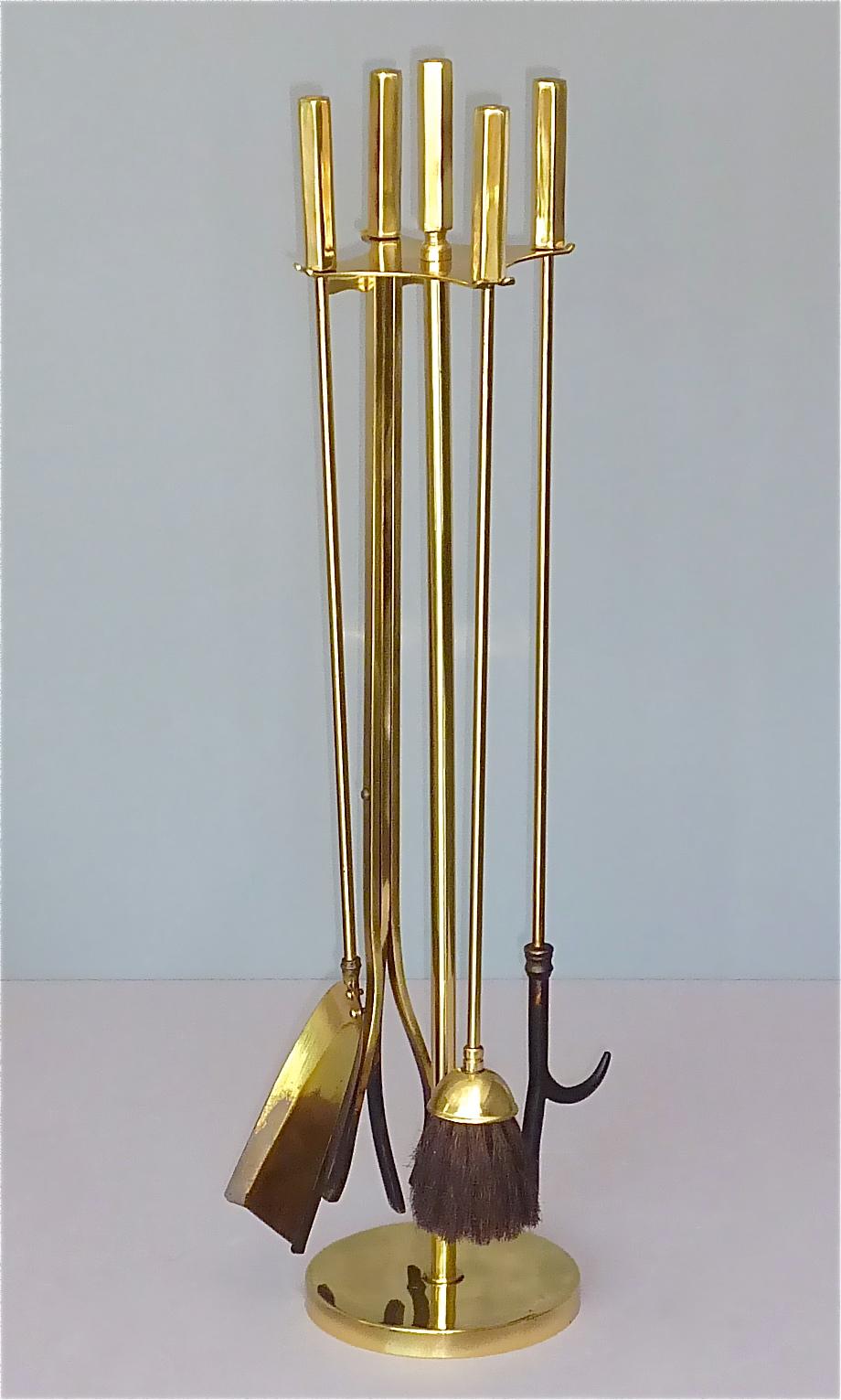French midcentury high quality fire place tool set including stand in gilt heavy brass with partly blackened iron with attribution to Maison Bagues or Maison Jansen, France around 1970s. The set of five pieces comprising stand, fireplace broom,