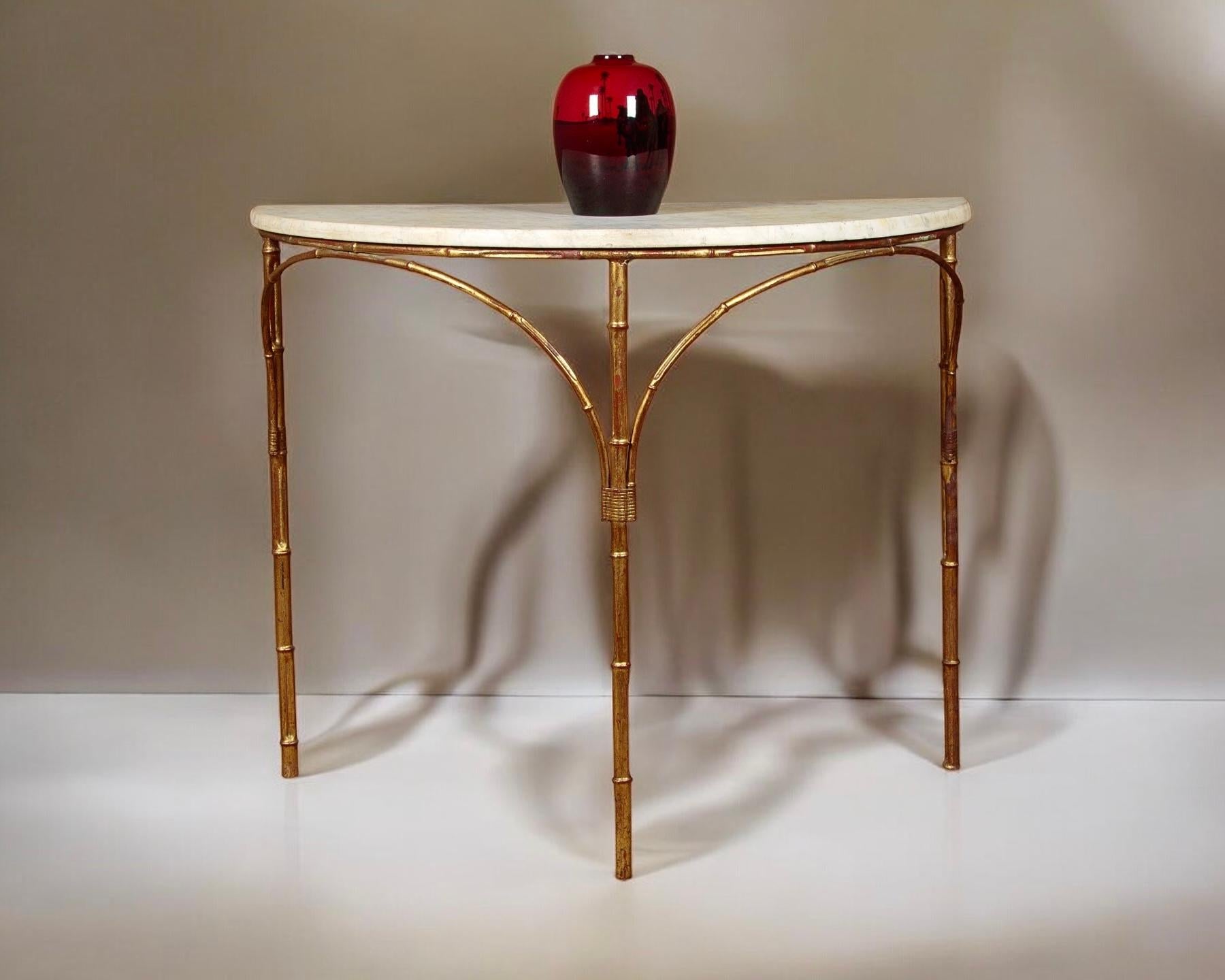 A Stylish Midcentury Gilt Metal Faux Bamboo and Marble-Topped Console or Side Table

A smart and elegant demilune-shaped table featuring a variegated marble top. It is supported by a delicate, slim-legged frame in the form of bamboo, with simulated