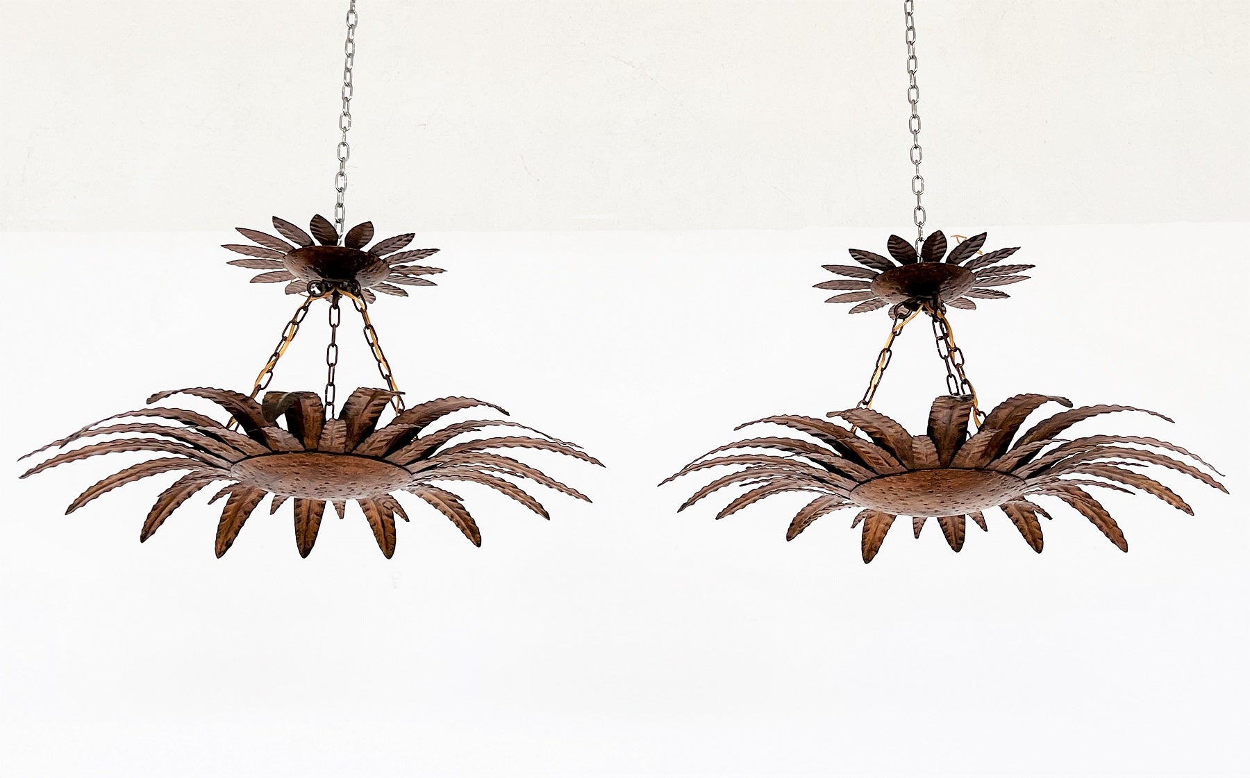 Gorgeous set of 2 pieces 2-tier chandeliers in the shape of big palm leaf flowers, made of gilt metal. 
Both chandeliers are hand-crafted and in very good vintage and working condition.
They were checked and cleaned, wires and bulb holders were