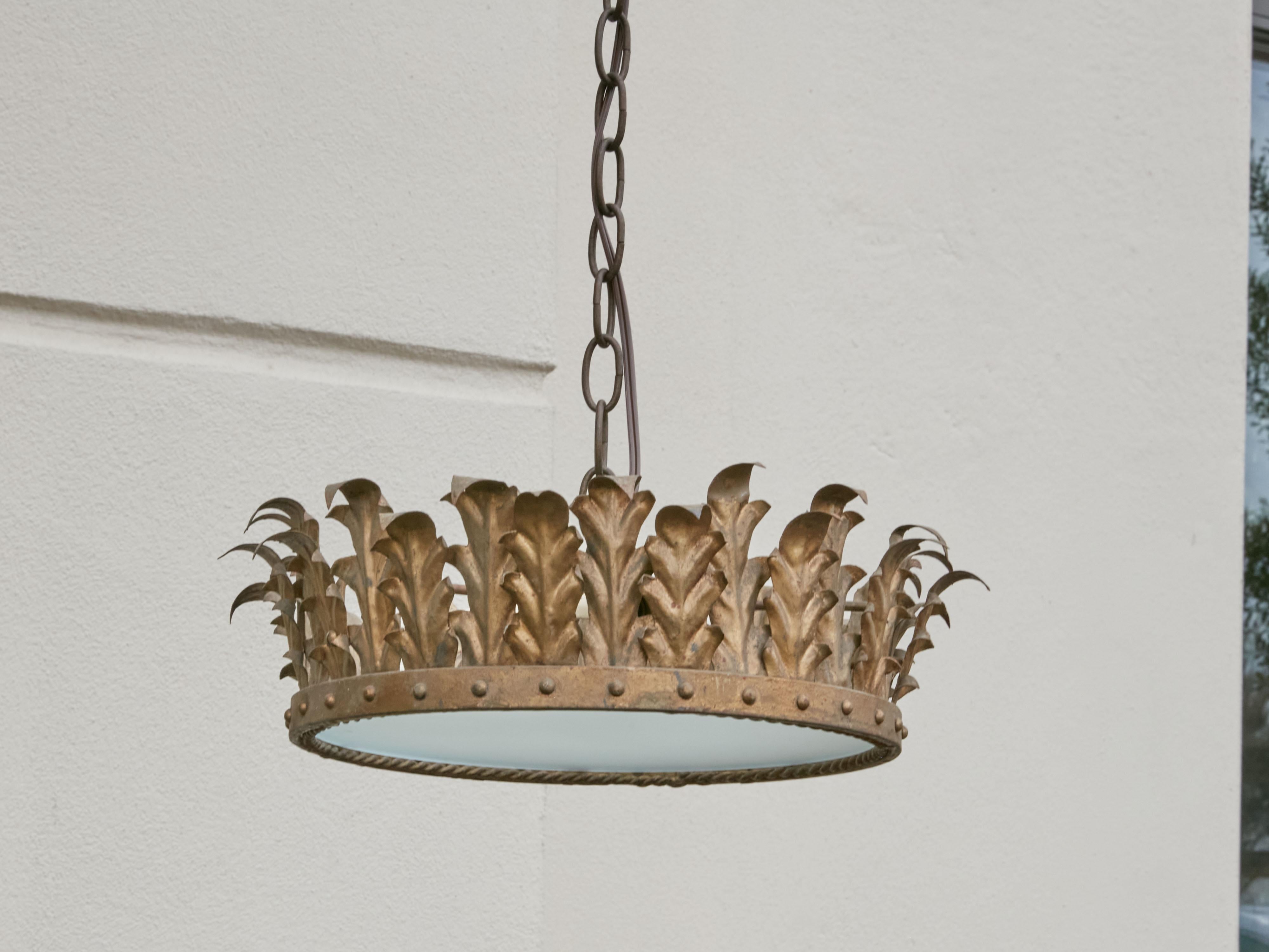 A Spanish vintage gilt metal three-bulb semi-flush crown light fixture from the mid-20th century, with frosted glass and new wiring. Created in Spain during the midcentury period, this crown chandelier features a decor of curving gilt metal foliage,
