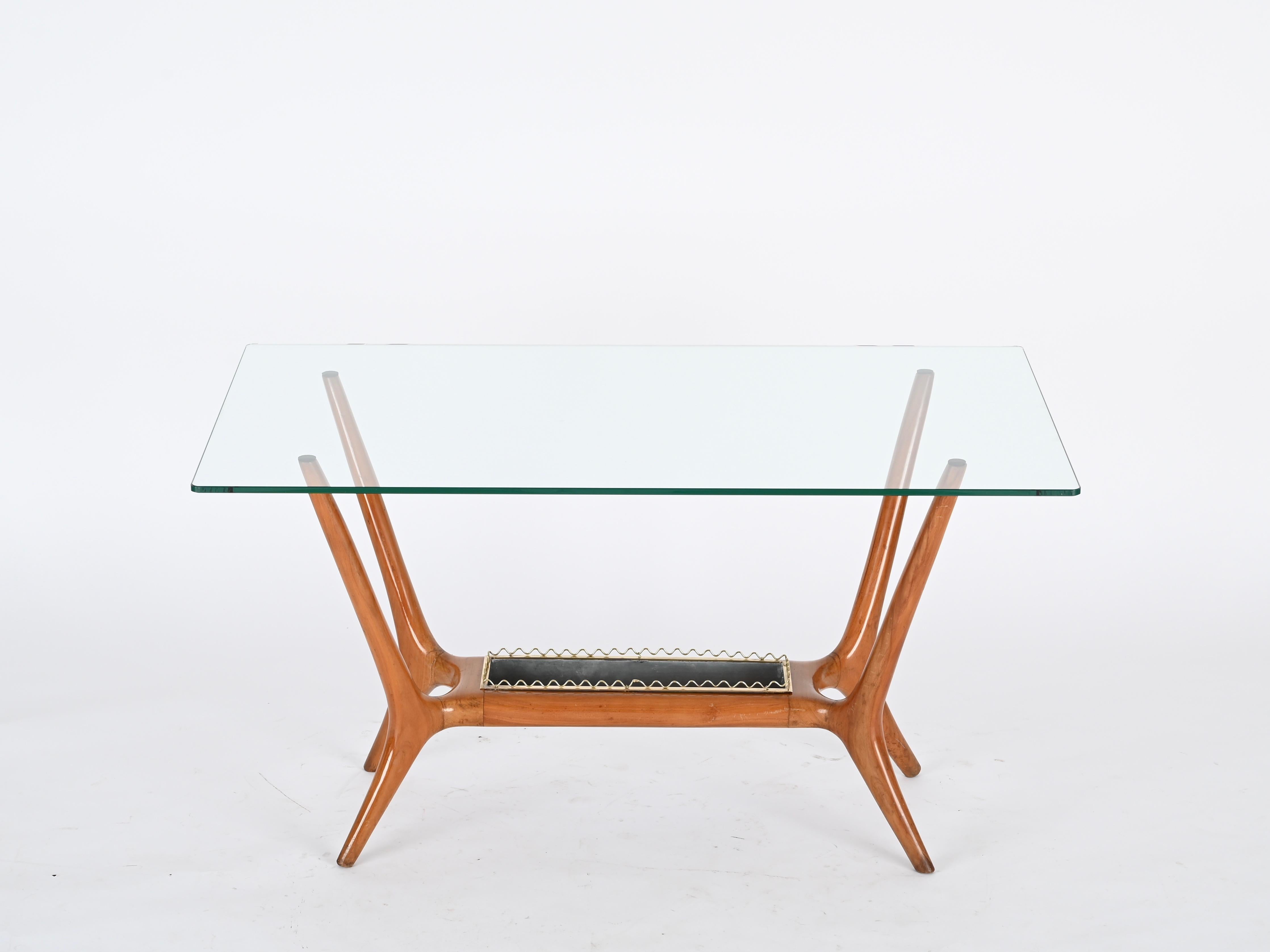 Fabuleuse et incroyablement rare table basse italienne du milieu du siècle en bois de noyer, laiton et métal avec un plateau en verre de cristal. Cette charmante table basse est attribuée à la vision du design emblématique de Gio Ponti et a été