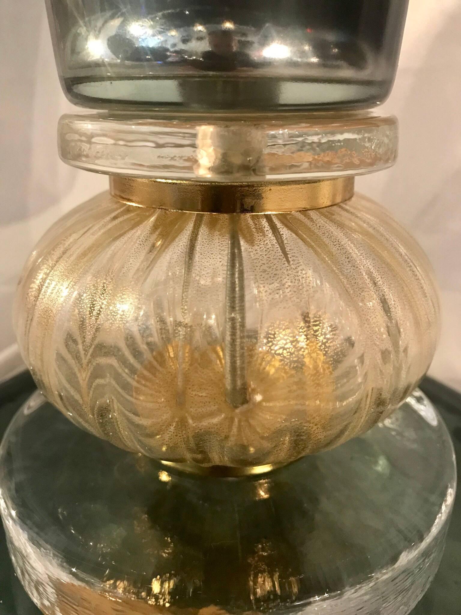 Une très élégante lampe de table italienne en verre soufflé de Murano dans une couleur très rare de vert anglais légèrement irisé avec une touche de verre clair soufflé contenant des inclusions d'or et une garniture en laiton dans le style de Gio