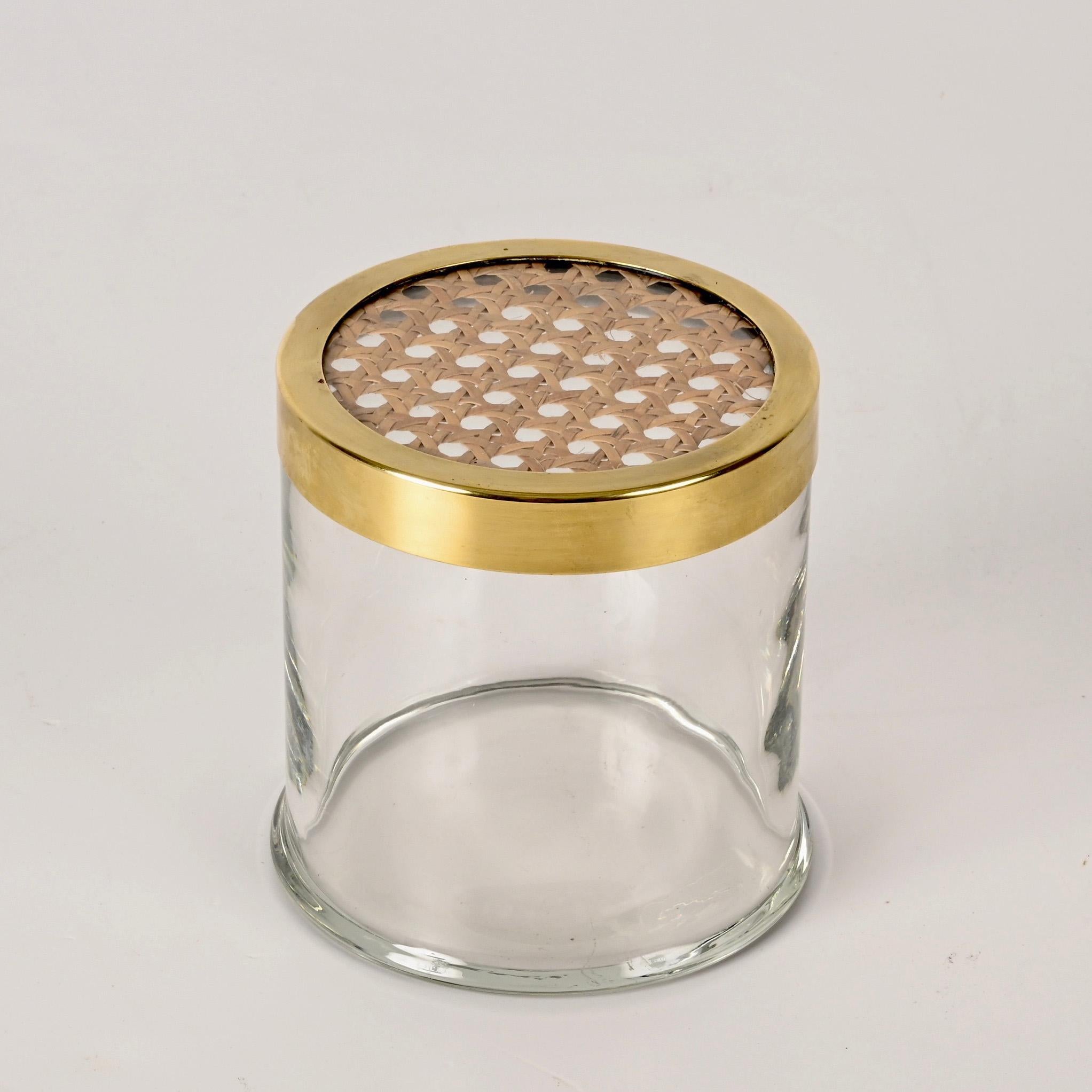 Preciosa caja redonda decorativa de mediados de siglo realizada en cristal transparente con una elegante tapa de latón y paja de Viena.  
Esta elegante caja se diseñó en Italia en los años 70 siguiendo el estilo de Christian Dior.

El contraste