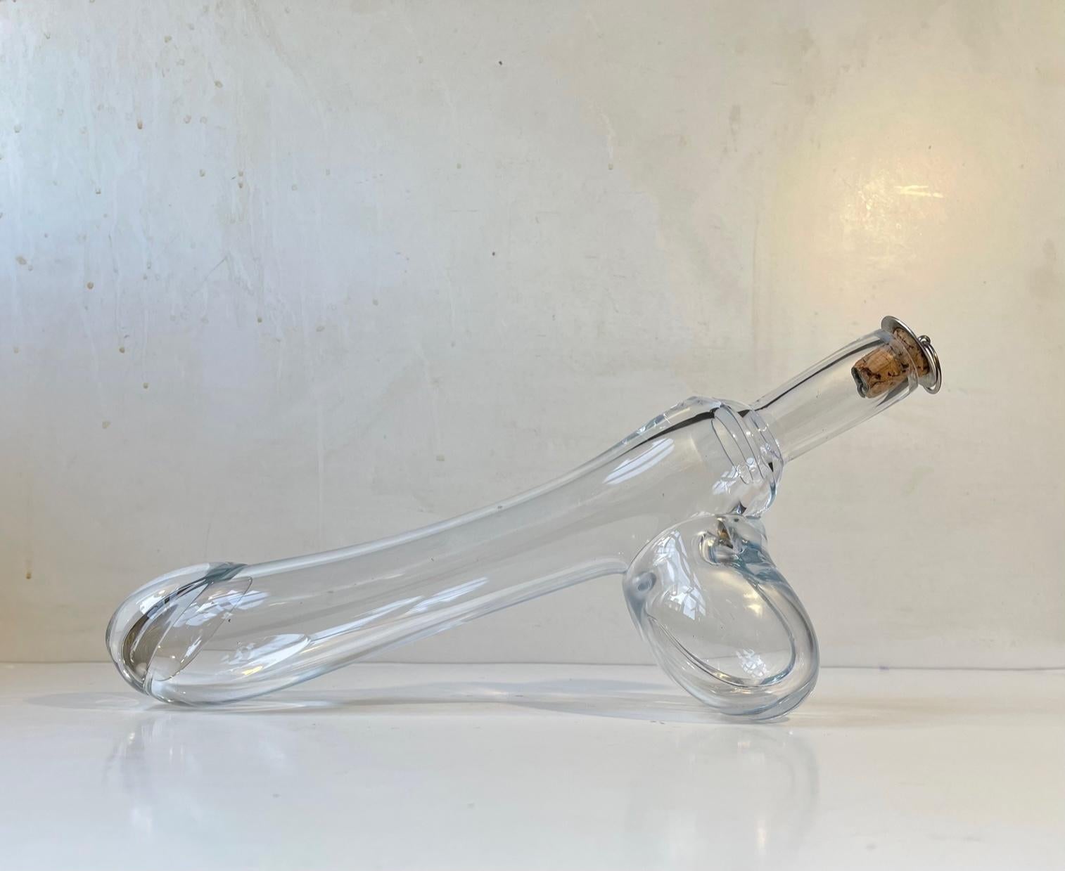 A mouth blown clear glass erotic decanter in shape of a Fallos/Penis. These curious decanters were made by employees at Holmegaard in Denmark during the 1960s and 1970s. It features its original silver-plated brass/cork stopper and can contain