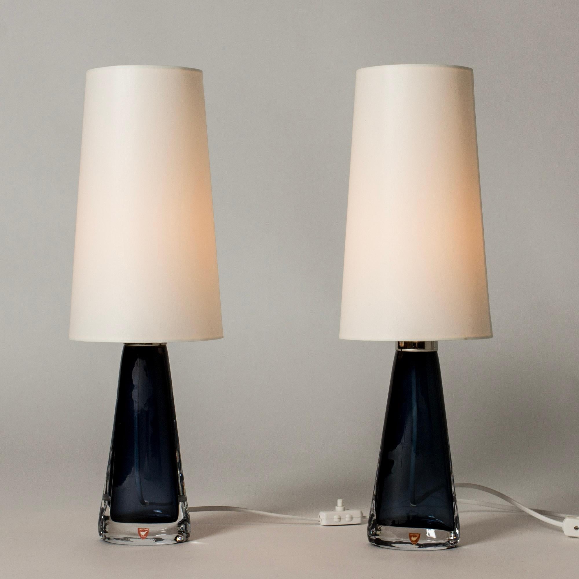Pair of crystal glass table lamps by Carl Fagerlund in a neat size. Made in dark blue glass in a narrow conical shape, almond shaped at the base. Beautiful translucent color, elegant design.