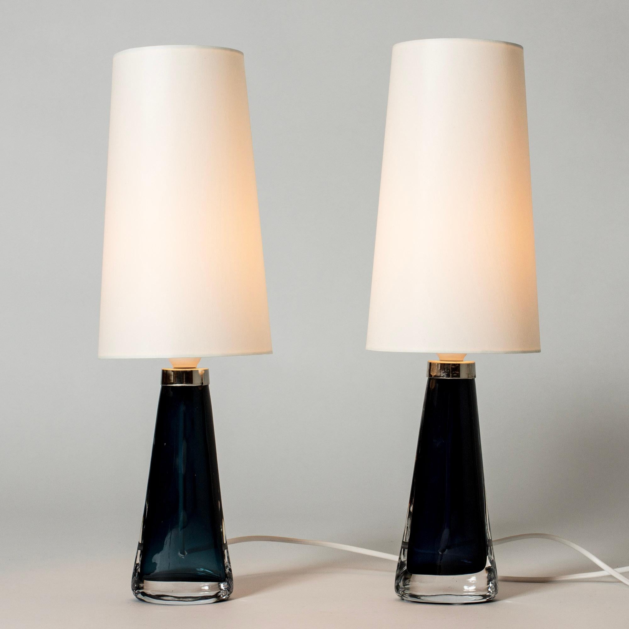 Pair of crystal glass table lamps by Carl Fagerlund in a neat size. Made in dark blue glass in a narrow conical shape, almond shaped at the base. Beautiful translucent color, elegant design.